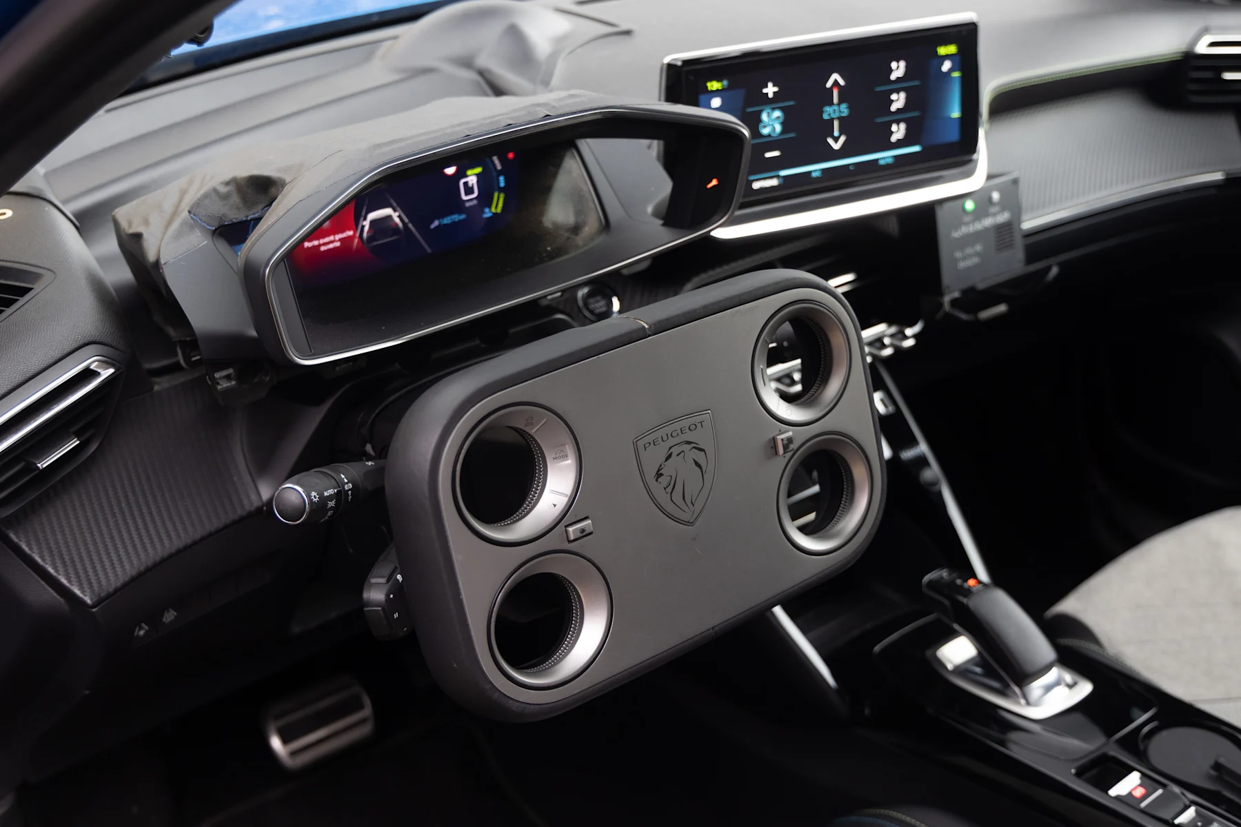 Intérieur d'une Peugeot e-208 GTi 2026, mettant en avant le volant futuriste « hypersquare » avec des commandes numériques.