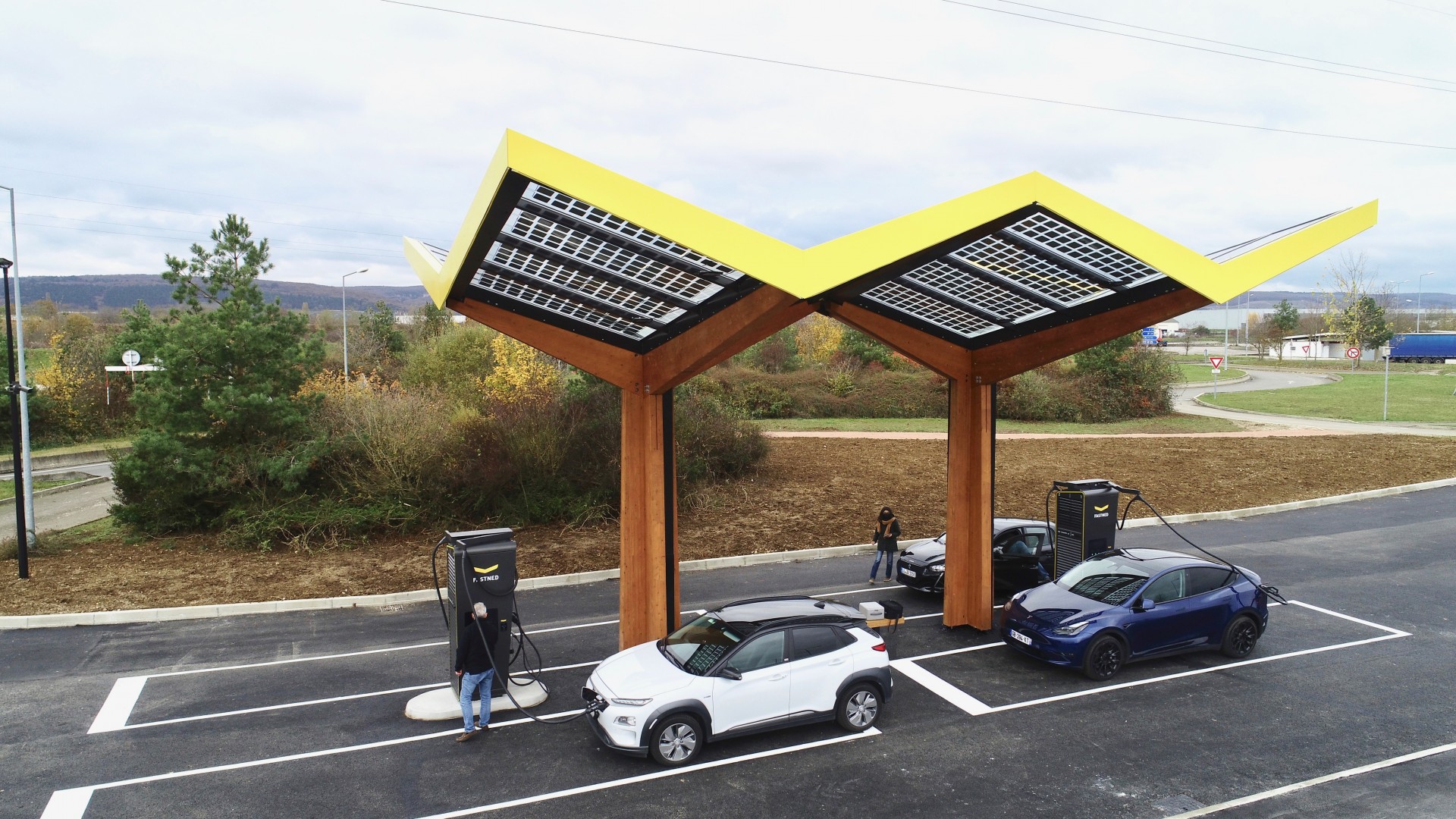 Une station de recharge moderne pour voitures électriques en France, avec plusieurs véhicules en charge.