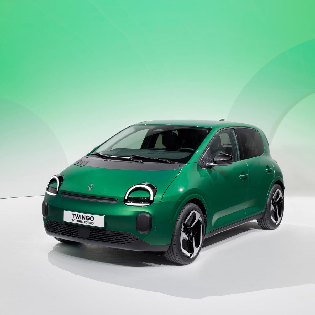 Une Renault Twingo 4 E-Tech jaune vif garée dans une rue de ville moderne.