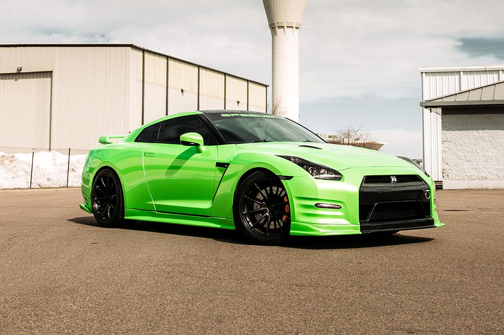 Une Nissan GT-R R35 fortement modifiée dans un garage de tuning professionnel.