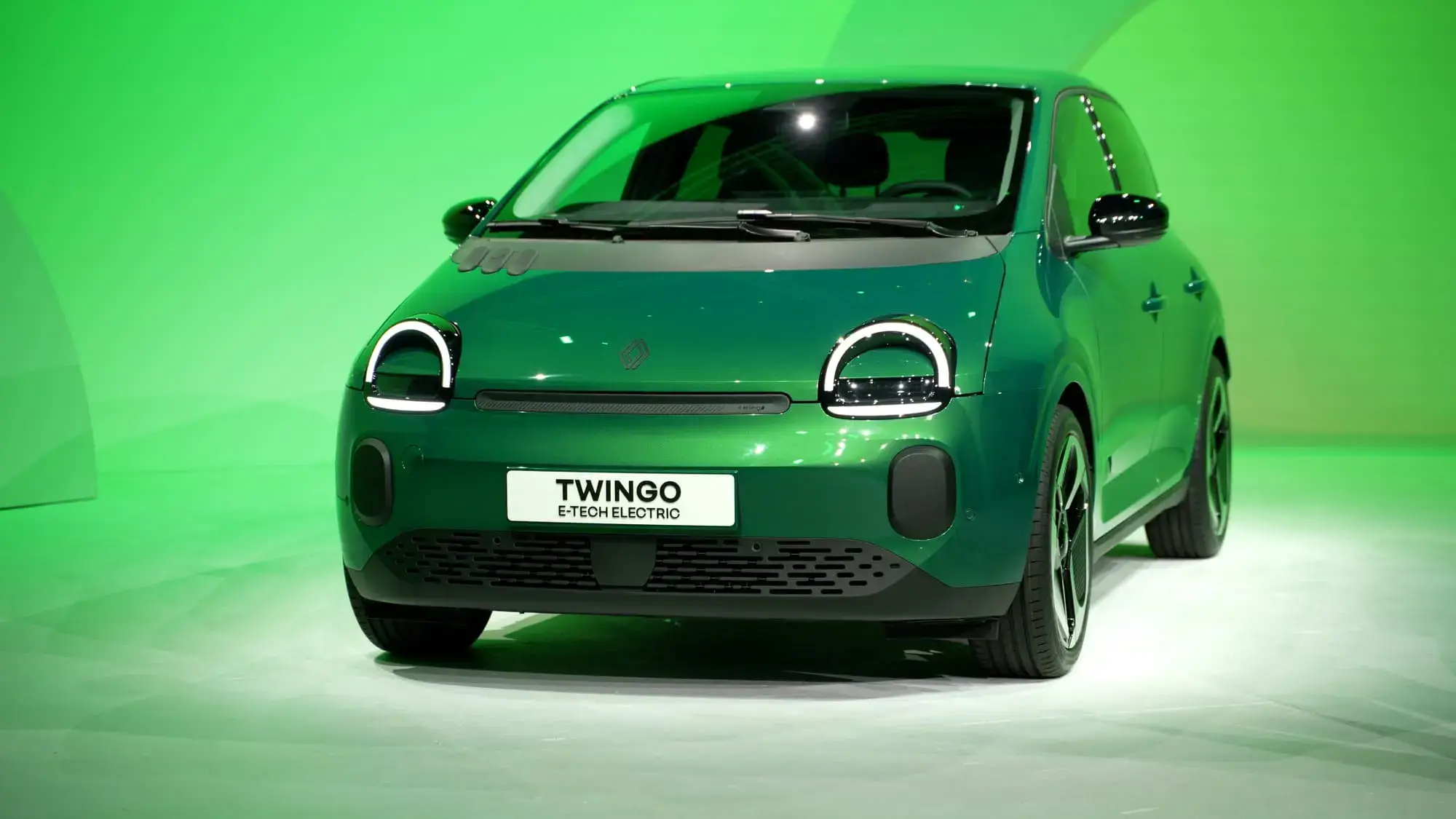 Trois citadines électriques, la Renault Twingo E-Tech, la Citroën ë-C3 et la Dacia Spring, garées en ville.
