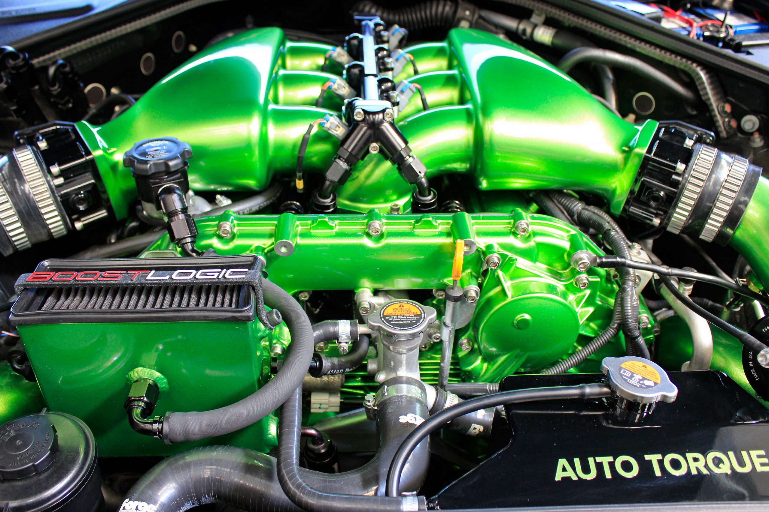 Vue rapprochée d'un moteur de Nissan GT-R R35 fortement modifié avec des turbos et des pièces de performance apparents.