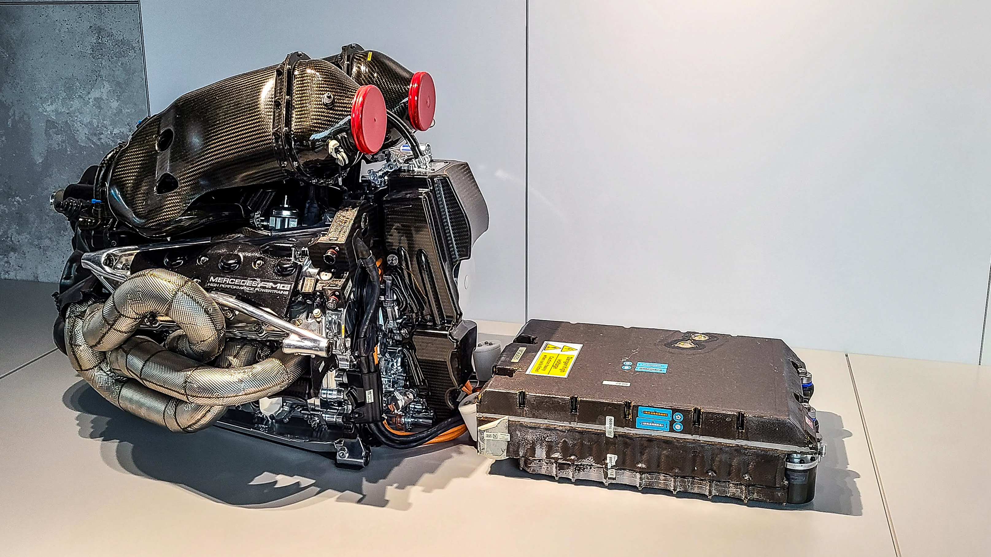 Vue détaillée d'un moteur hybride de Formule 1, avec ses composants complexes et ses systèmes de récupération d'énergie.