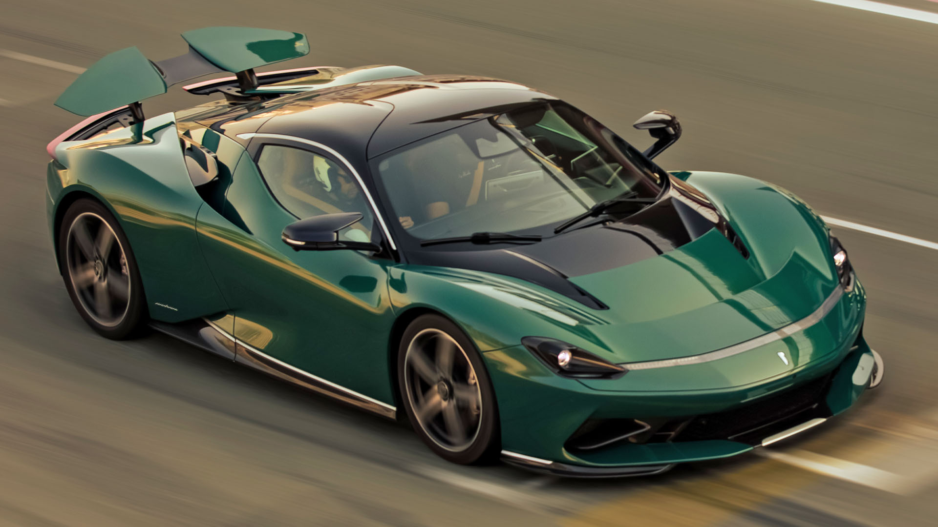 La Pininfarina Battista en pleine accélération sur une piste d'essai, avec un arrière-plan flou pour accentuer la vitesse.