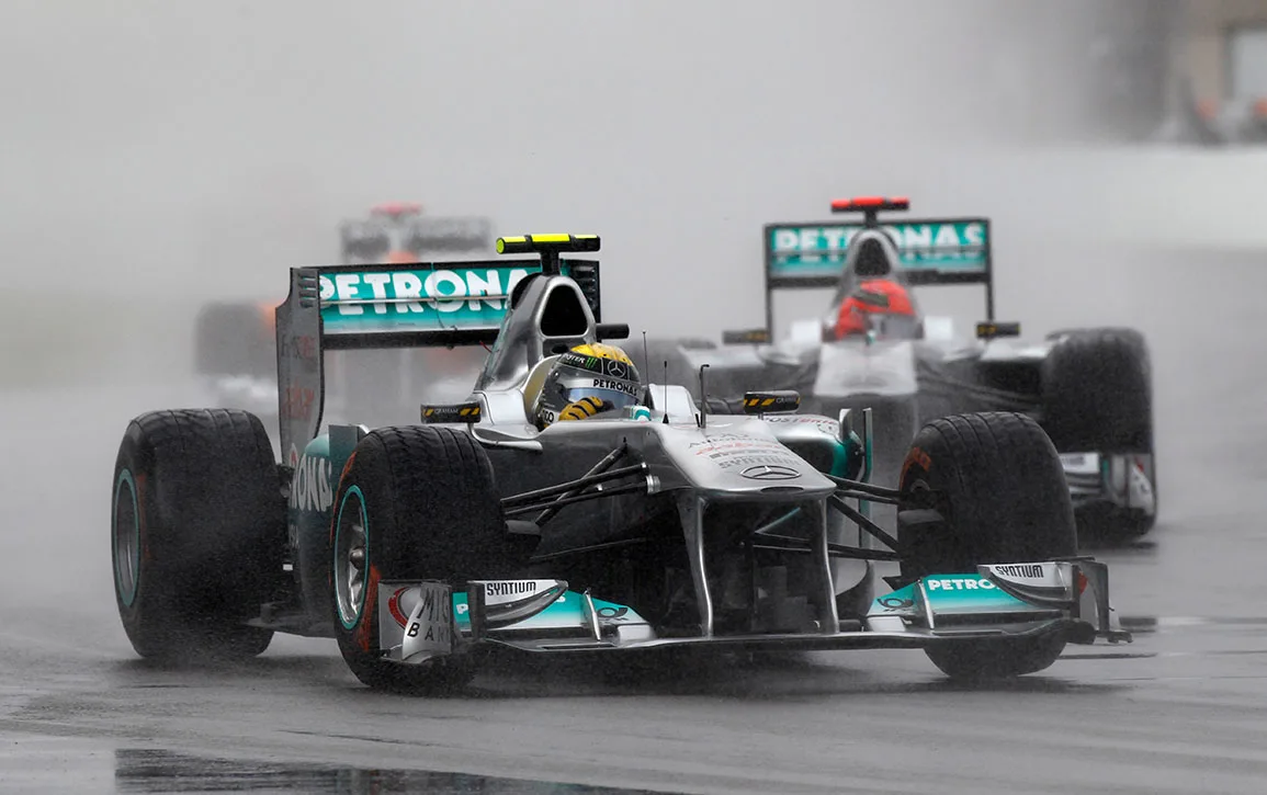 Une Mercedes de Formule 1 argentée et noire en pleine course sur le Circuit Gilles-Villeneuve, avec des tribunes et des arbres en arrière-plan.