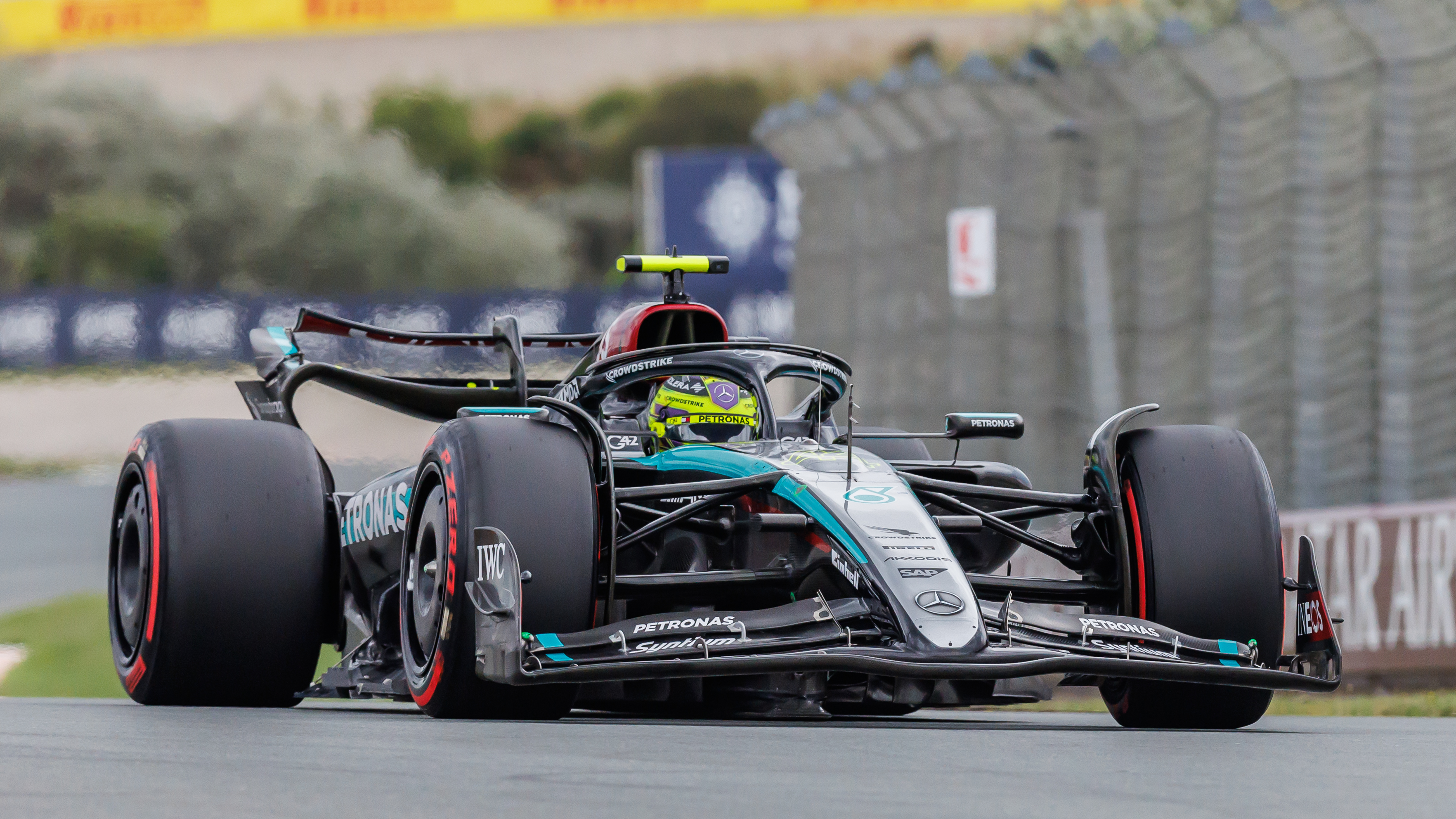 La monoplace Mercedes W15 en pleine course sur un circuit, montrant sa vitesse et son design aérodynamique.