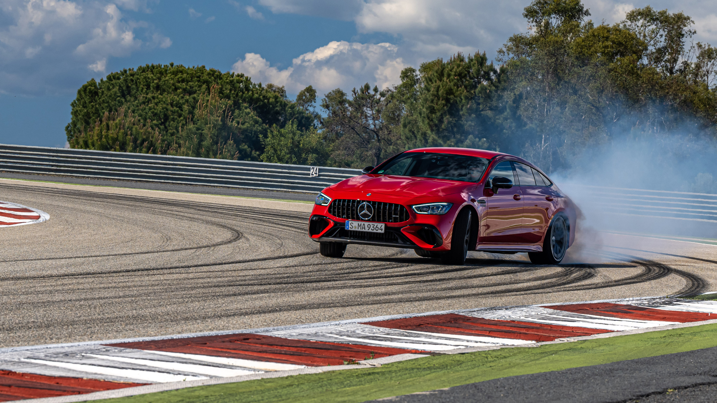 Mercedes-AMG GT 63 S E Performance en virage sur un circuit, avec de la fumée de pneu, illustrant sa performance sportive.