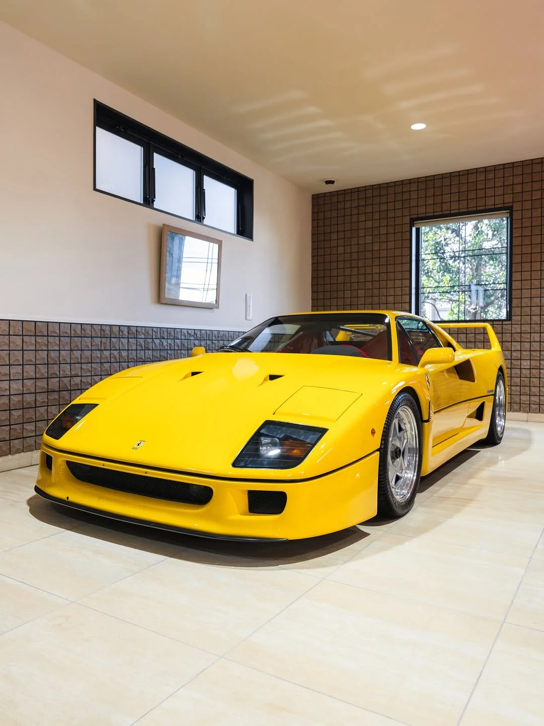 Une Ferrari F40 jaune immaculée, garée dans un garage de collectionneur, symbolisant la rareté et la valeur.