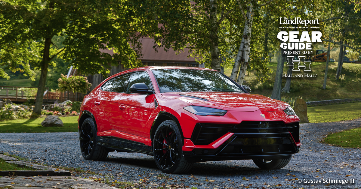 Vue latérale d'un Lamborghini Urus S 2023 noir garé devant un bâtiment moderne en verre.