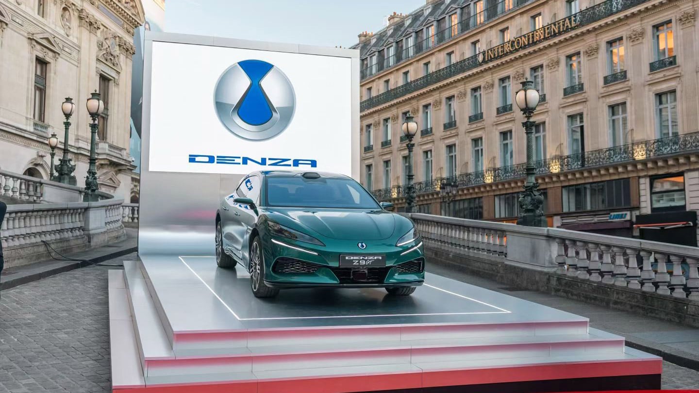 Une Denza Z blanche branchée à une borne de recharge rapide en Europe, avec le câble de recharge bien visible.