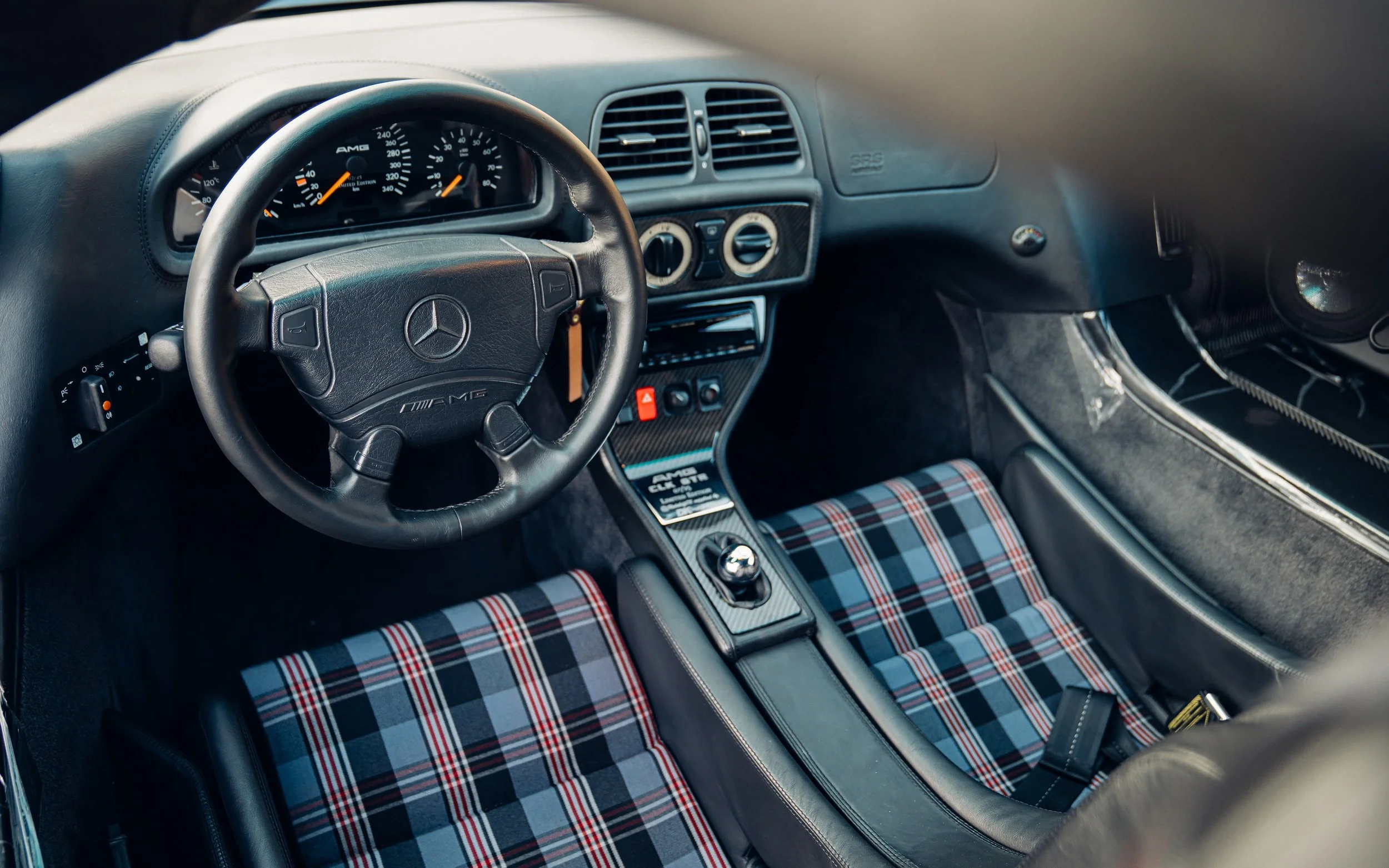 L'intérieur détaillé d'une Mercedes-Benz CLK GTR, montrant le volant, le tableau de bord et les sièges de course.