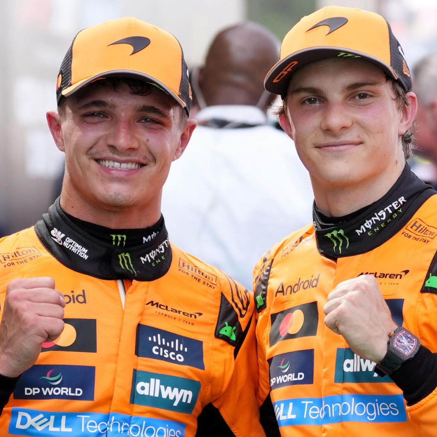 Oscar Piastri et Lando Norris, pilotes McLaren, posant ensemble dans leurs tenues d'équipe.