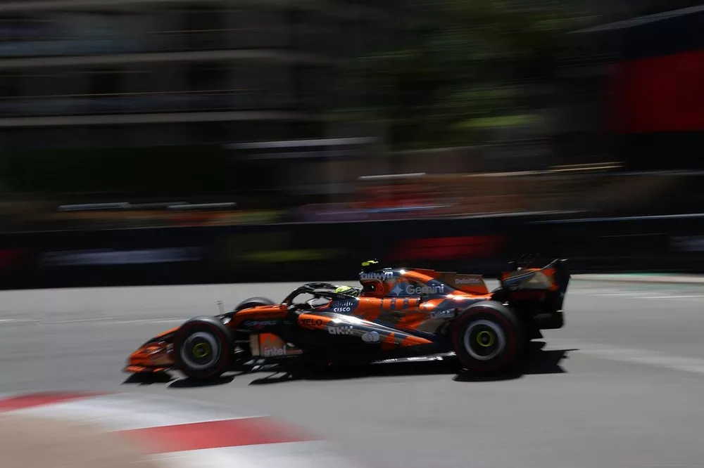 Une McLaren MCL40 de Formule 1 négociant un virage serré à Monaco, avec les bâtiments emblématiques de la Principauté en arrière-plan.
