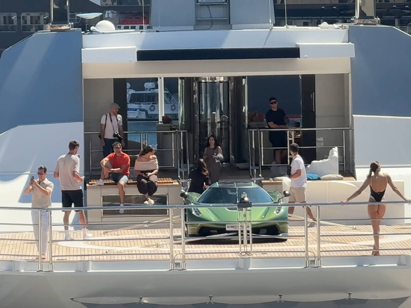 Une Koenigsegg Jesko Absolut blanche et noire garée devant un casino à Monaco, avec des passants qui la photographient.