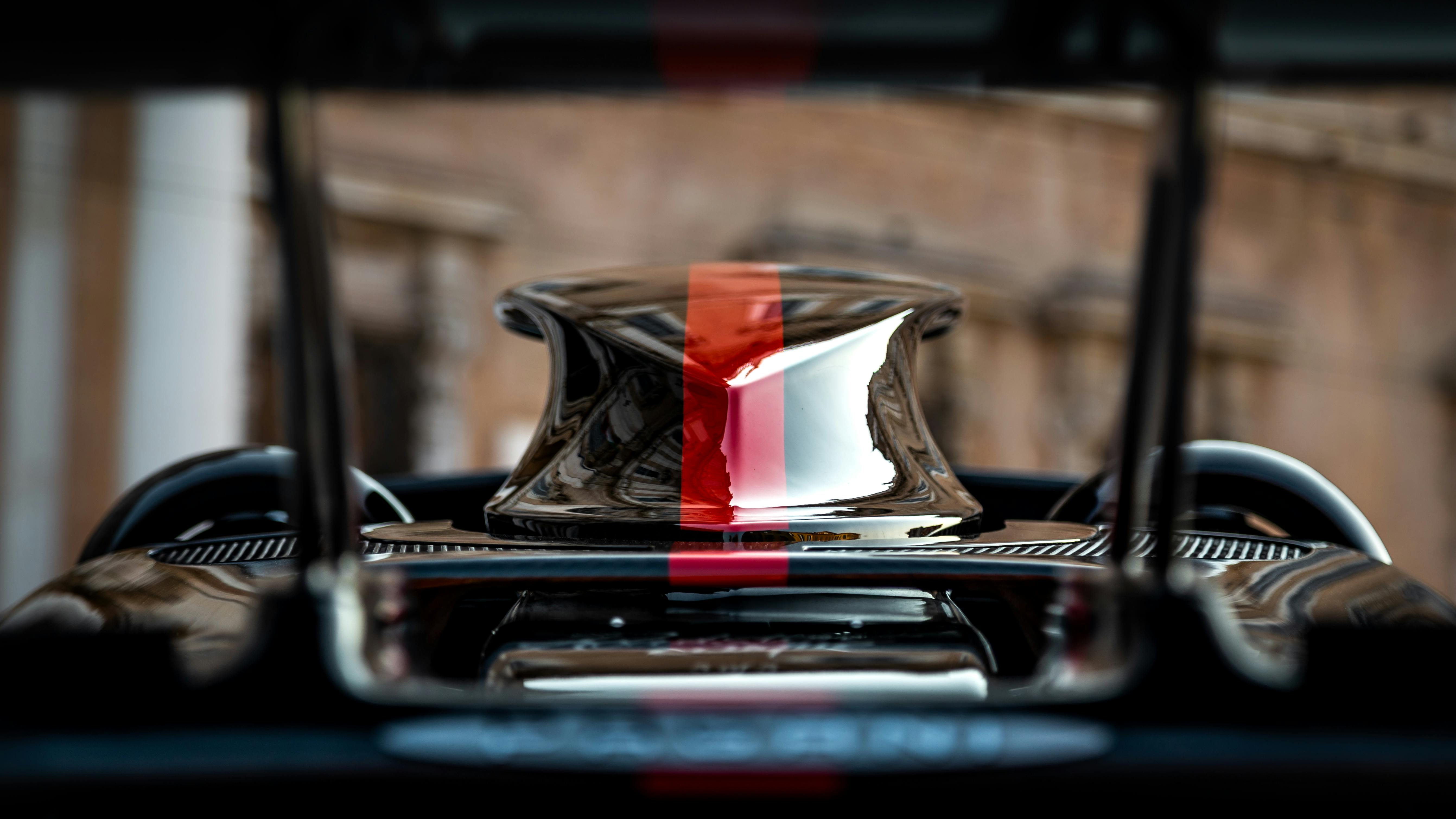 Gros plan sur le moteur d'une supercar avec un mainteneur de batterie et des vérifications de fluides, illustrant les étapes clés de la préparation hivernale.