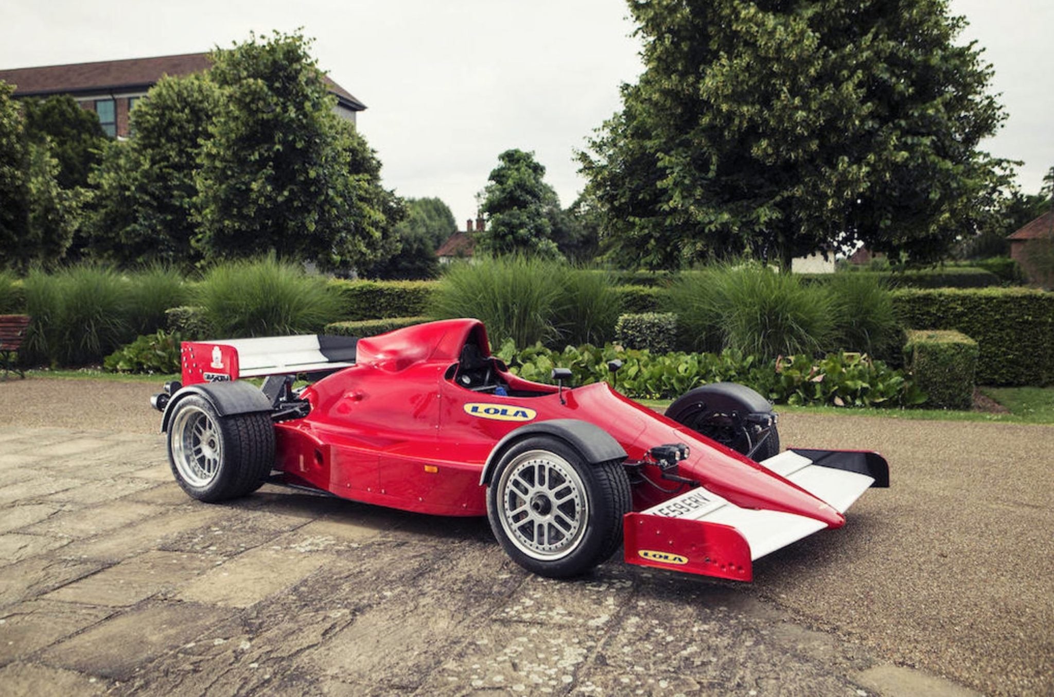 Vue détaillée d'un châssis de F1 avec des ajouts pour l'homologation routière, tels que des pare-chocs et des phares.