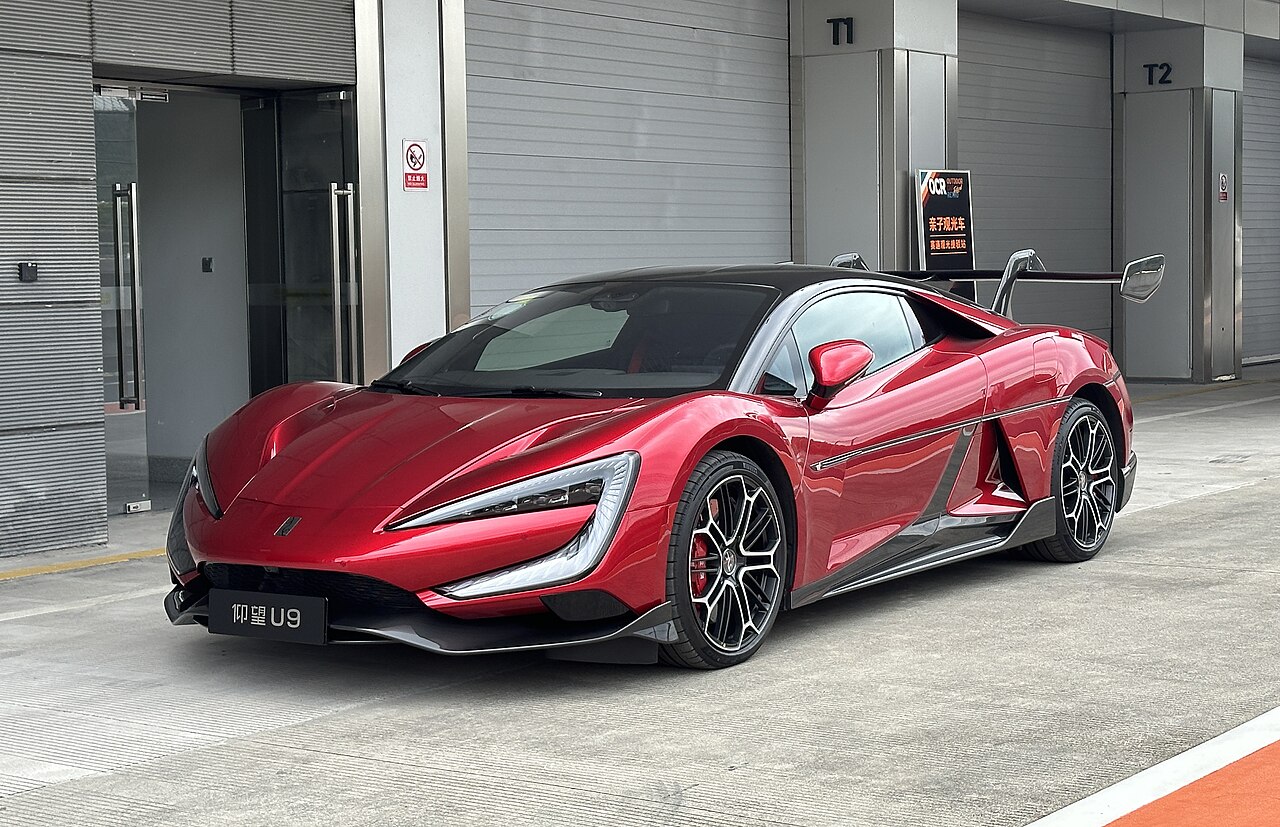 Une hypercar électrique BYD Yangwang U9 Xtreme noire et or en pleine accélération sur une piste de course.