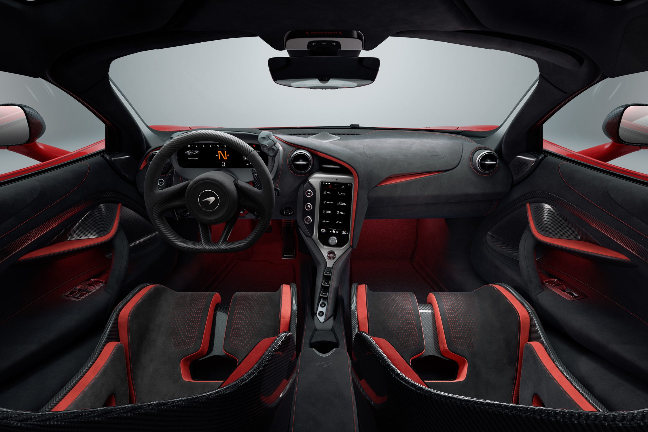 Intérieur détaillé d'une McLaren 750S, montrant le tableau de bord numérique, le volant sport et les sièges en Alcantara.