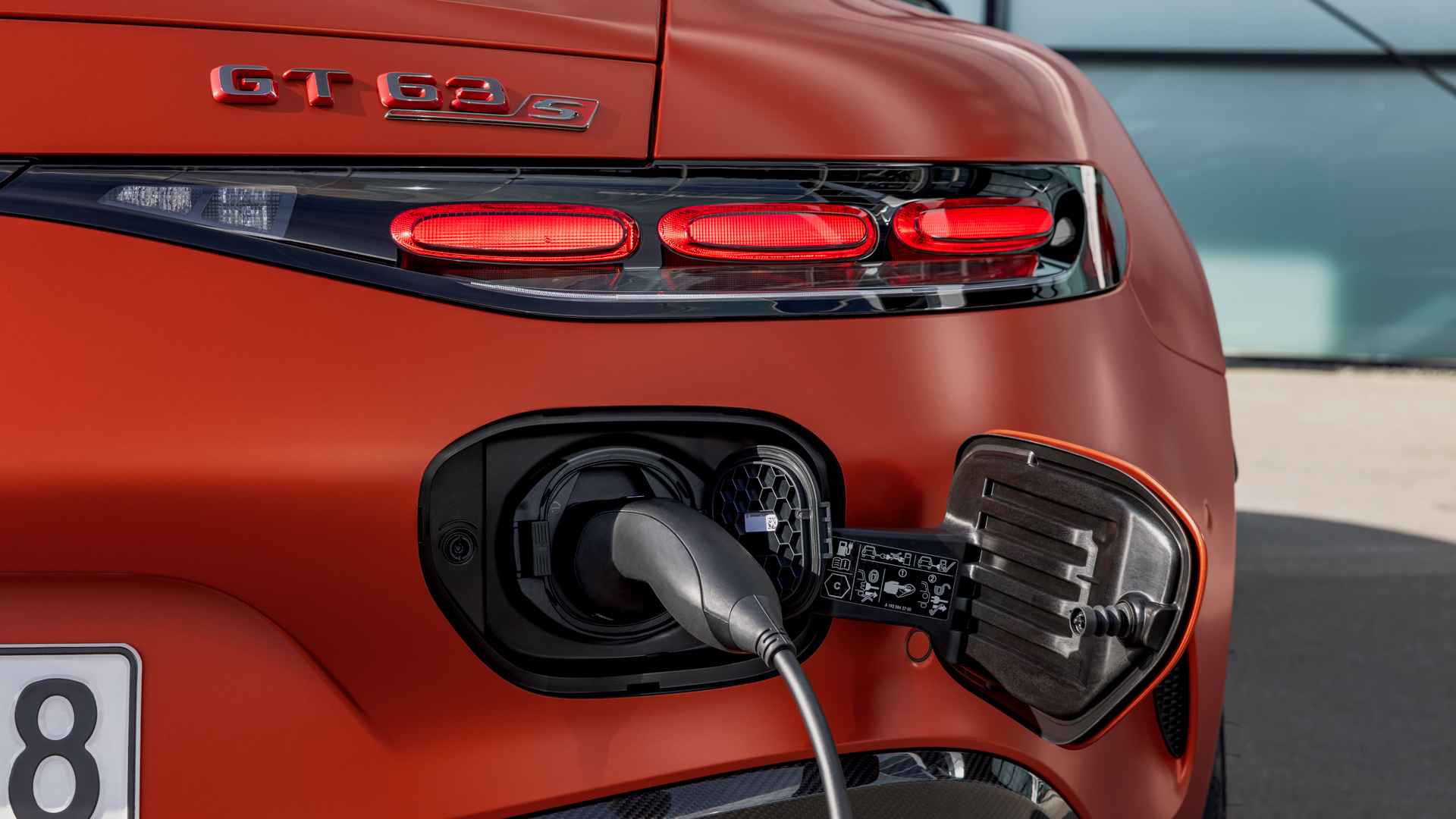 Gros plan sur le port de recharge de la Mercedes-AMG GT Coupé 4 portes électrique, avec un câble de recharge haute puissance connecté.