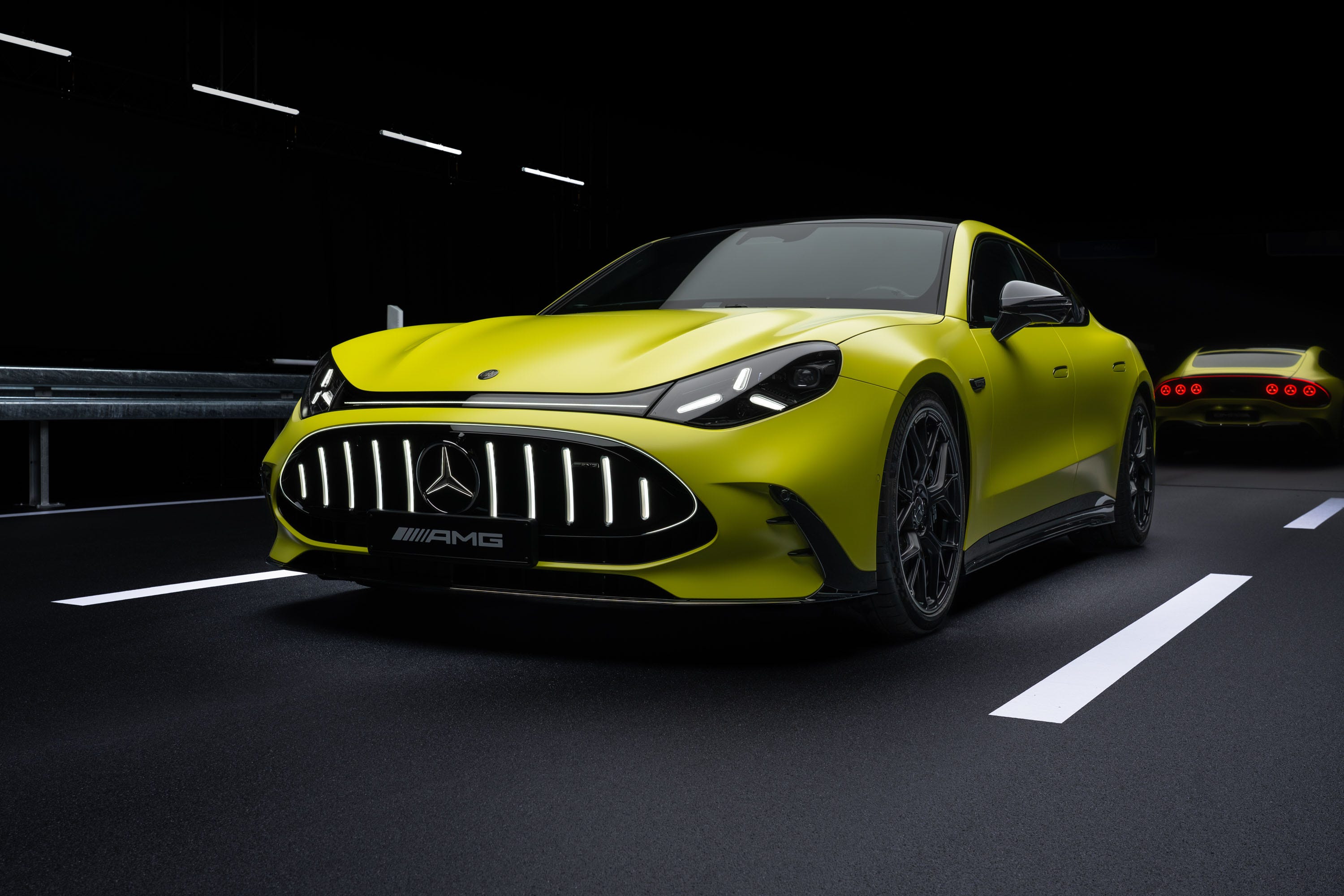 Vue extérieure de la Mercedes-AMG GT Coupé 4 portes électrique, montrant son design sportif et ses phares LED allumés.