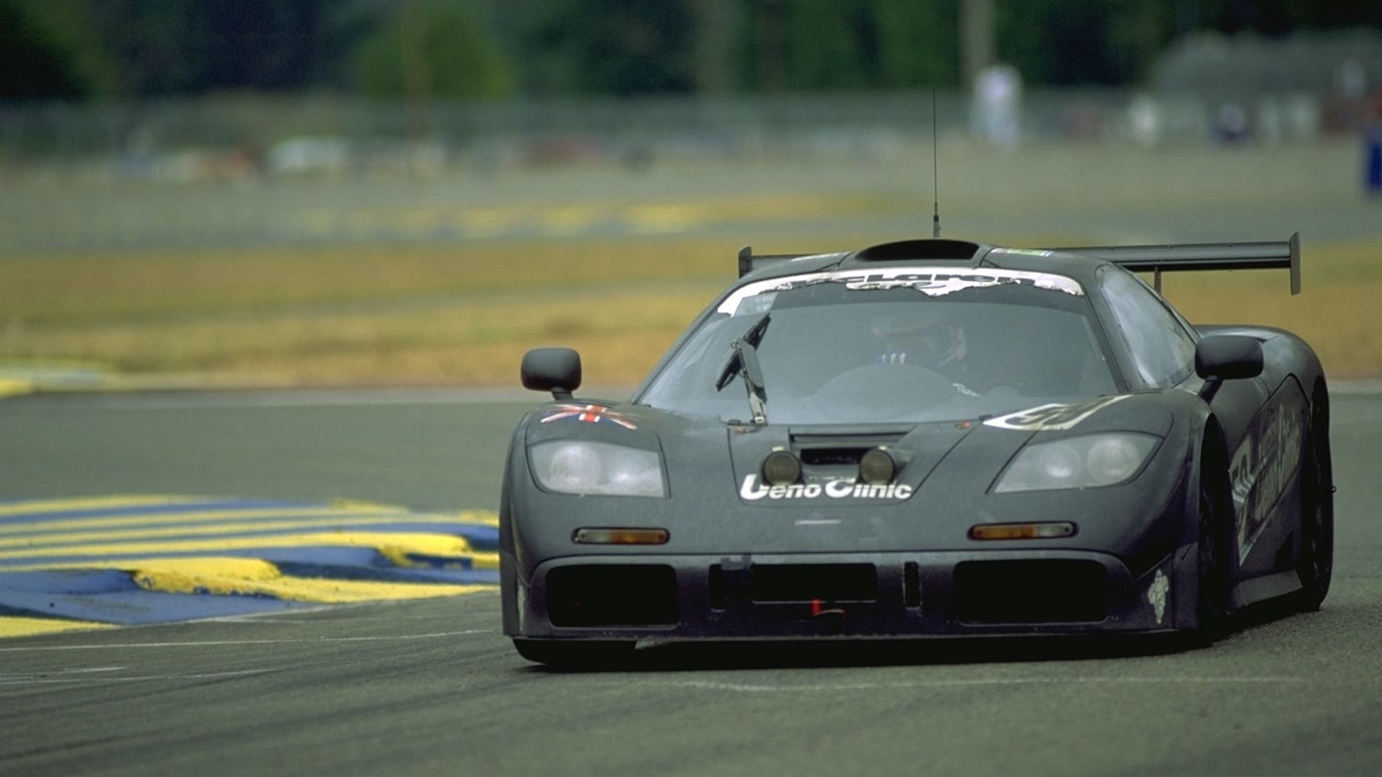 Une McLaren F1 GTR de course, numéro 59, en pleine action sur le circuit des 24 Heures du Mans en 1995.