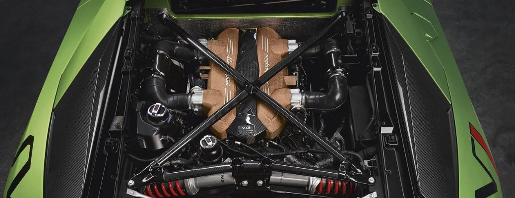 Vue détaillée d'un moteur de supercar propre et bien entretenu, avec des mains effectuant une vérification des fluides.