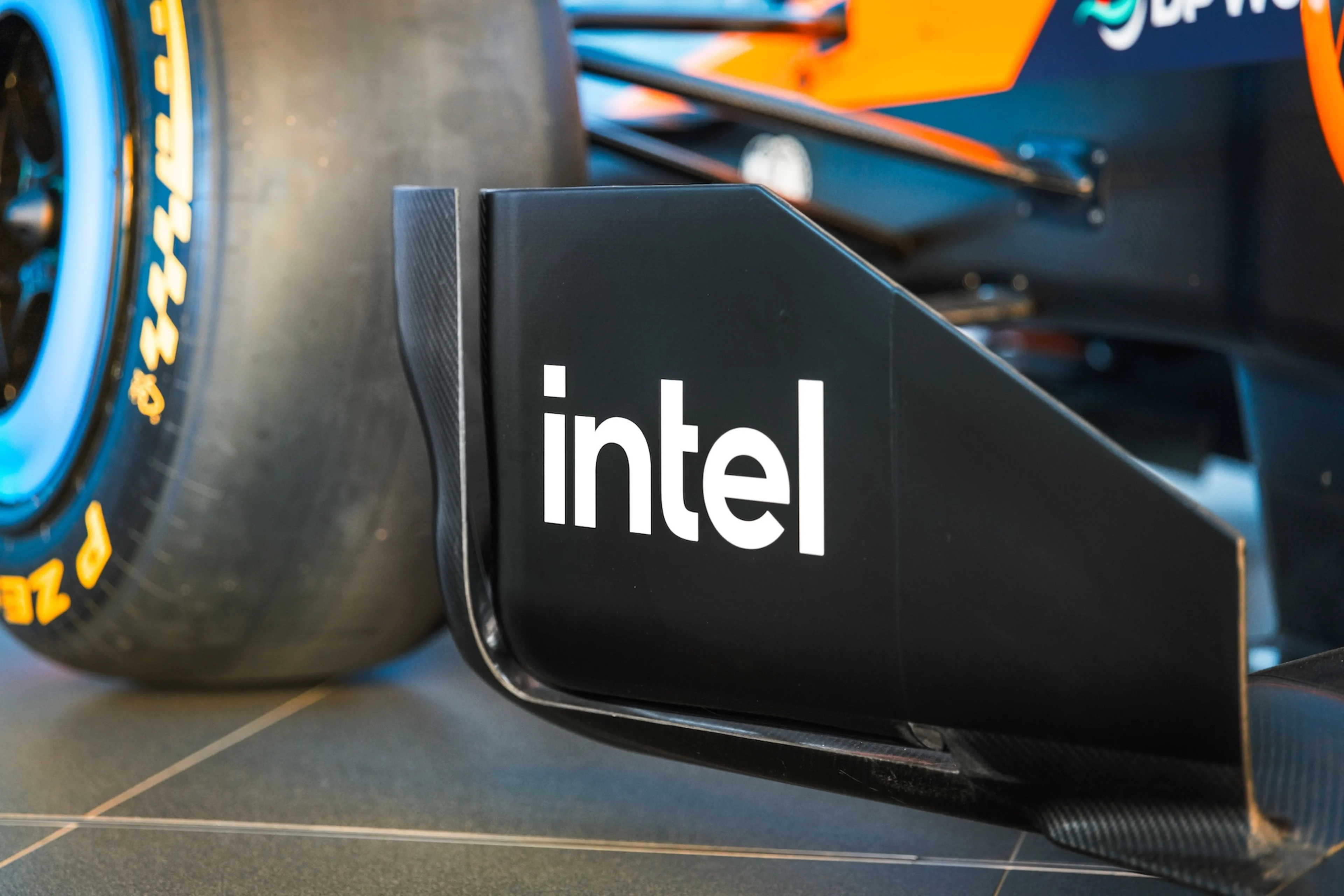 Logos d'Intel et de McLaren Racing superposés sur un arrière-plan technologique, évoquant la puissance de calcul et l'innovation.