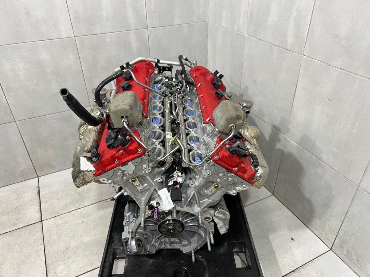 Image détaillée du moteur V12 du Ferrari Purosangue, avec ses composants en fibre de carbone et le logo Ferrari.