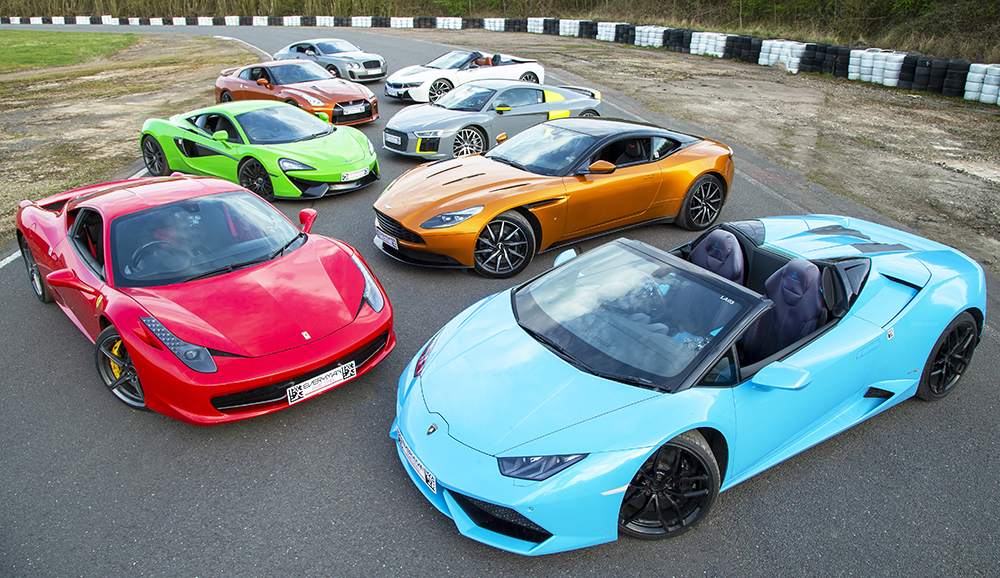 Une supercar rouge fonçant sur une piste de course, avec le conducteur visible et le soleil couchant en arrière-plan.