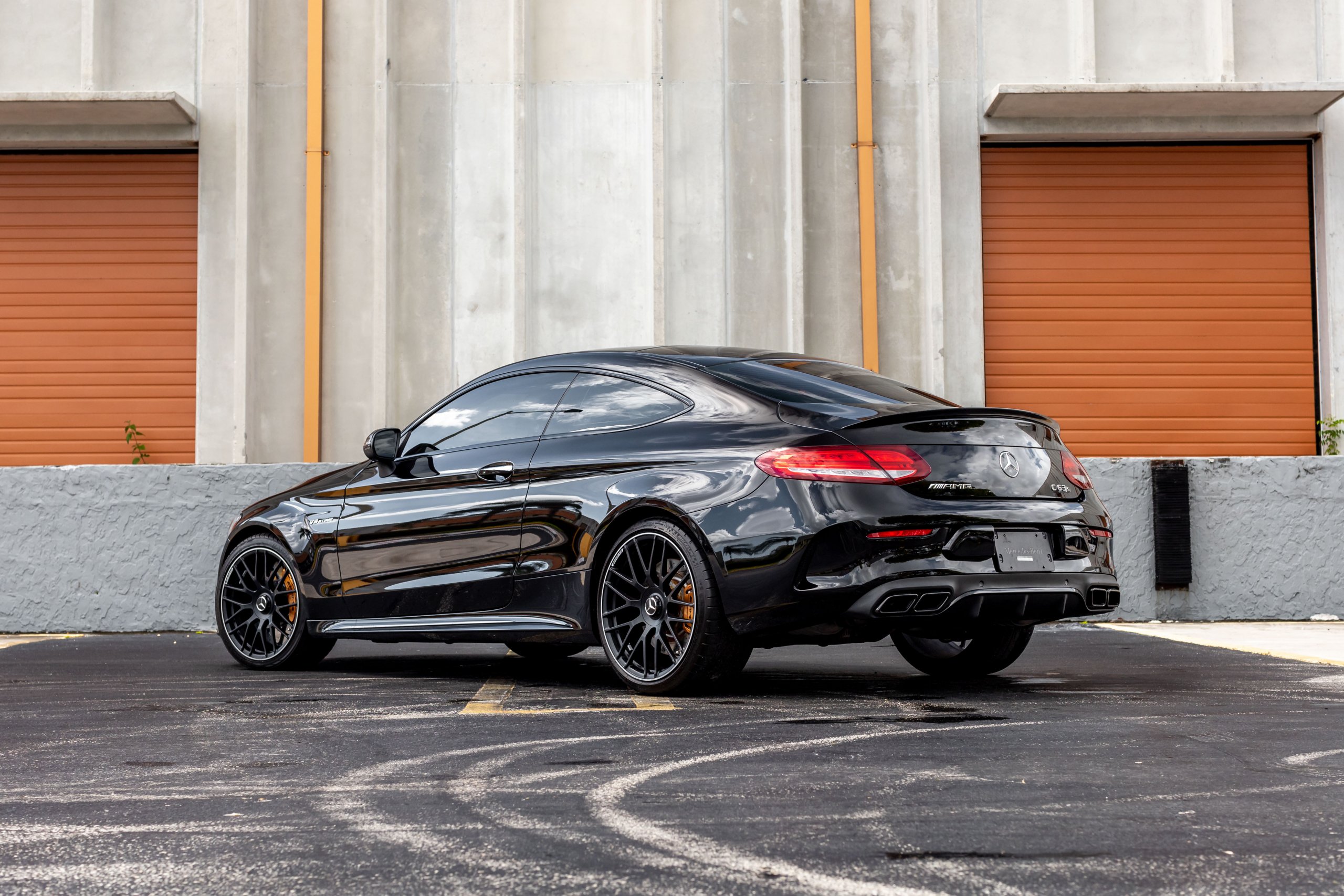 Une Mercedes-AMG C 63 S Coupé W205 argentée en mouvement sur une route sinueuse.