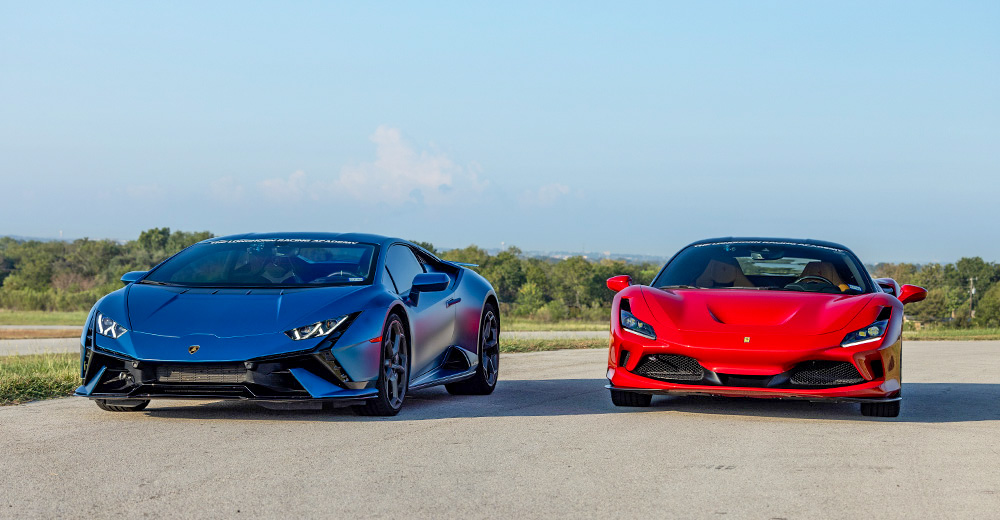 Une Ferrari 296 GTB rouge et une Lamborghini Huracán Evo jaune garées côte à côte sur une route panoramique avec vue sur la mer.