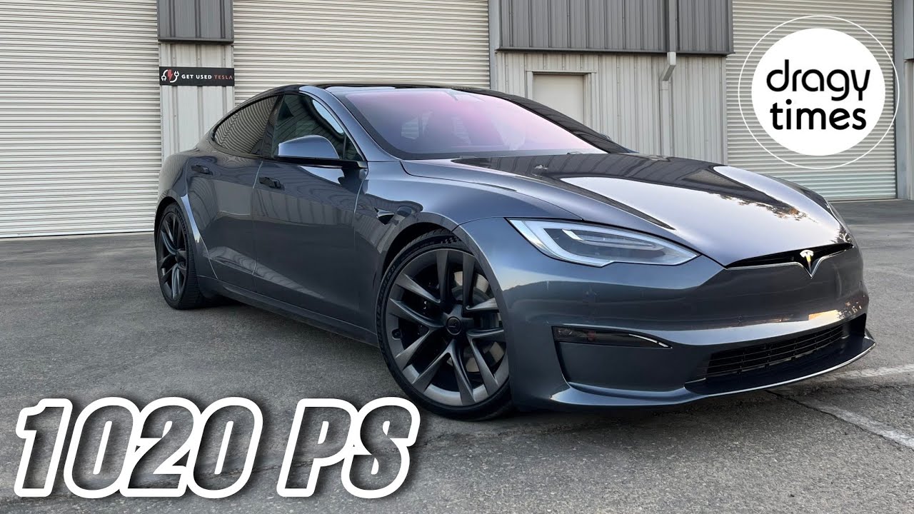 Une Tesla Model S Plaid blanche en pleine accélération sur une piste de course, avec un flou de mouvement.