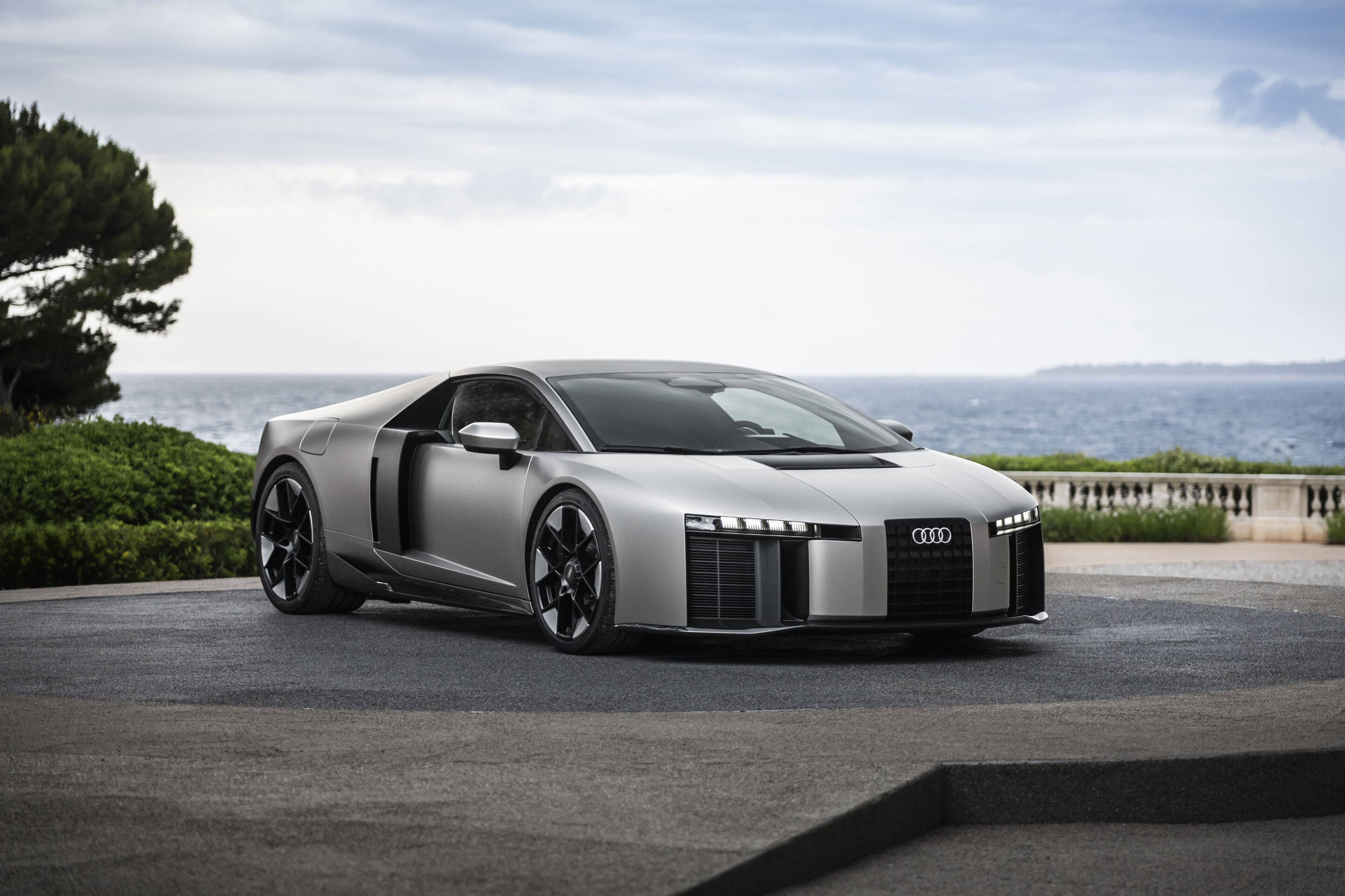 Vue extérieure de l'Audi Nuvolari, un concept-car gris argenté avec des lignes sportives et des phares LED distinctifs.