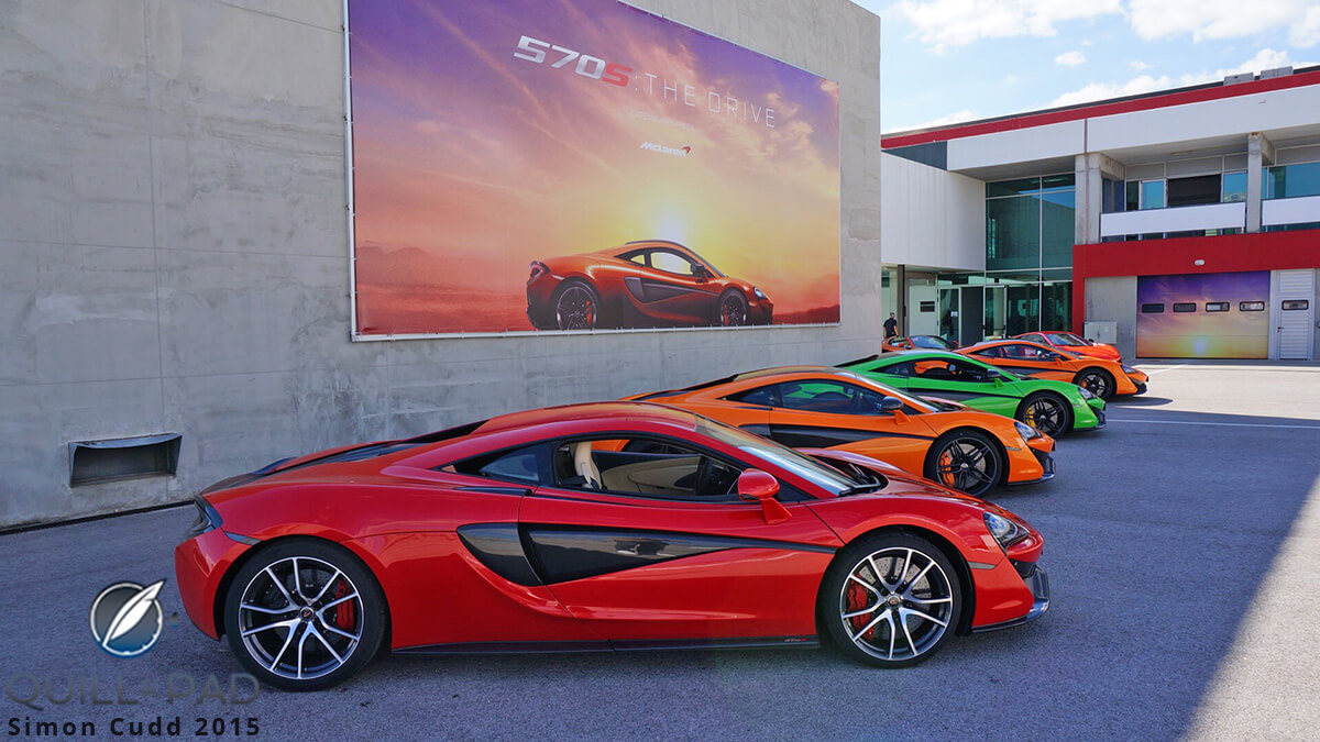 Une McLaren 570S de couleur vive, garée dans un showroom moderne et lumineux, mettant en valeur son design sportif.