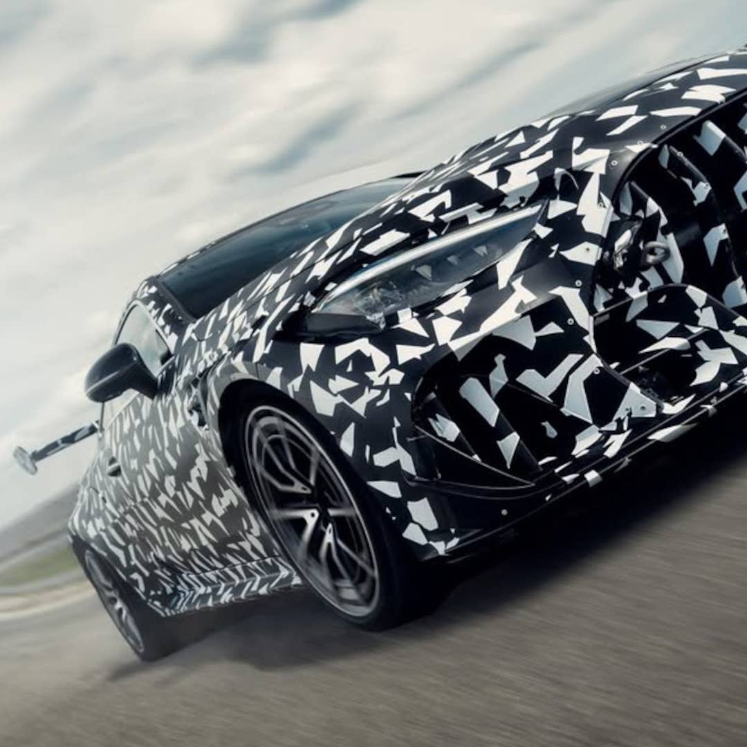 Vue de face d'une Mercedes-AMG Mythos CLE en mouvement sur un circuit, mettant en évidence son splitter avant agressif et ses larges prises d'air.