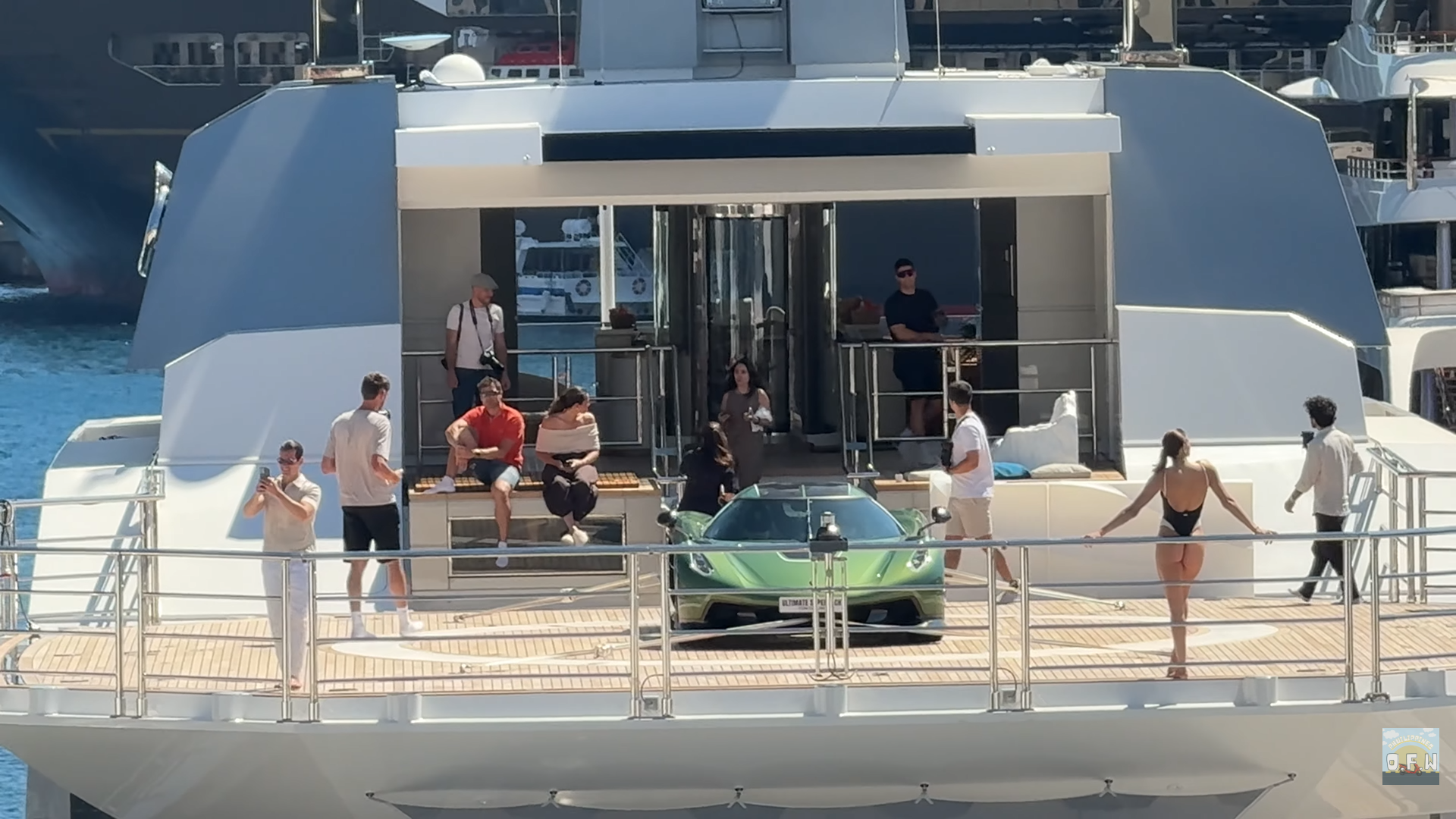 Une Koenigsegg Jesko Absolut blanche garée sur le pont d'un superyacht, avec la côte de Monaco en arrière-plan.