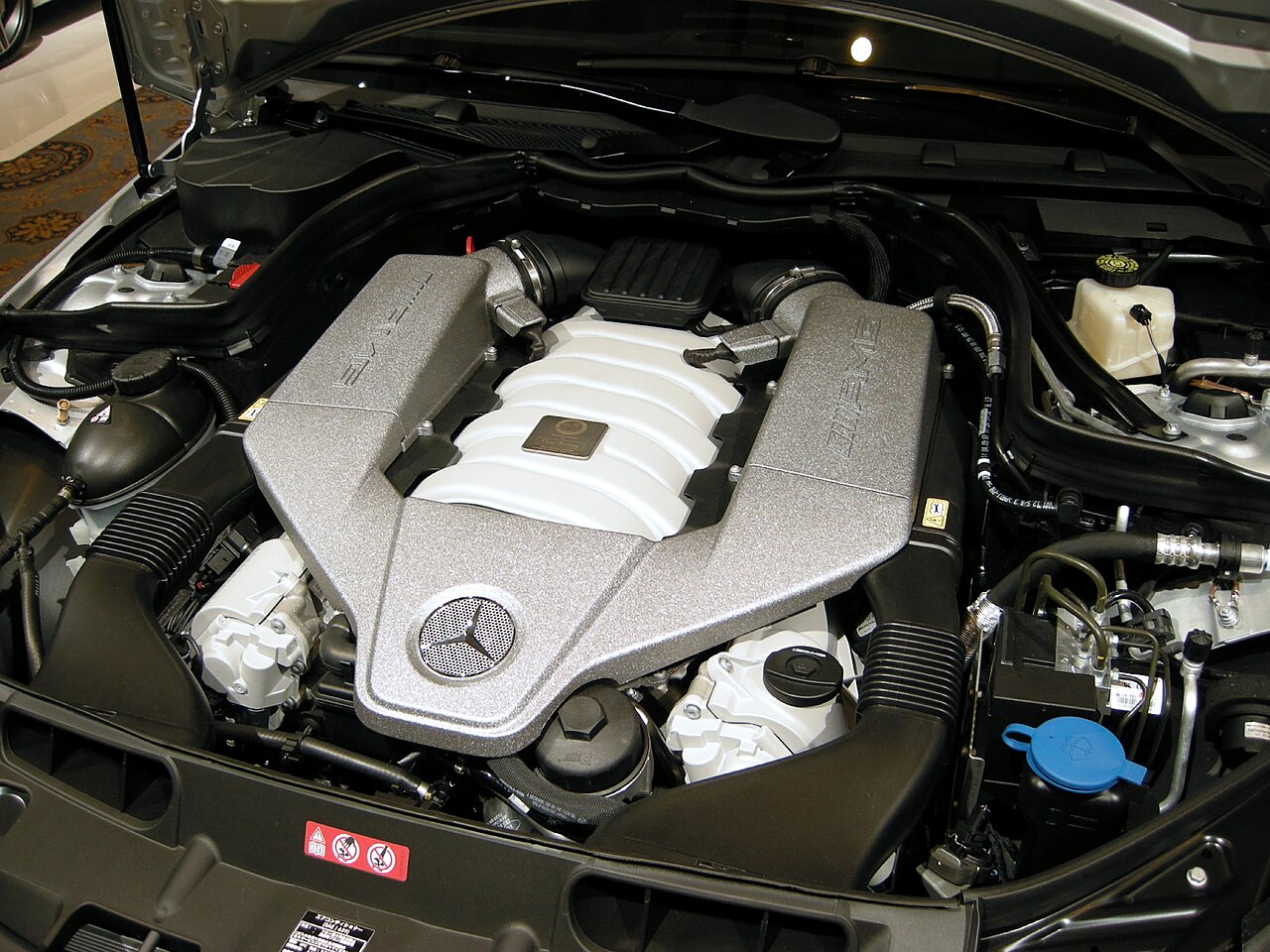Vue détaillée du moteur six cylindres d'une Mercedes-AMG C 63, mettant en évidence ses composants mécaniques.
