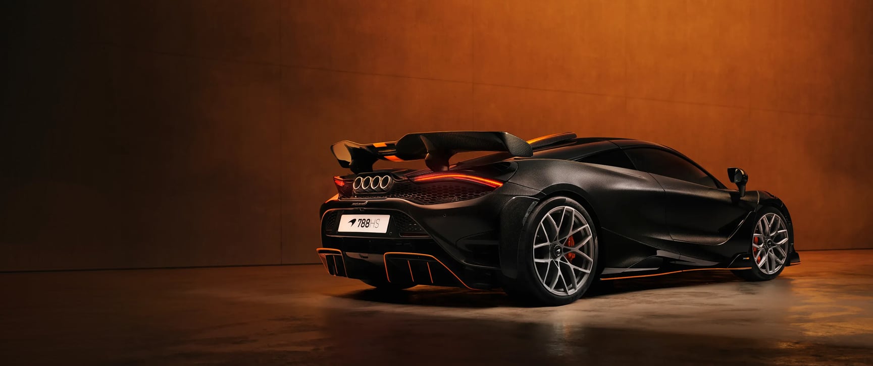 Une McLaren 788HS garée dans un garage moderne, mettant en valeur ses lignes aérodynamiques et son design élégant.