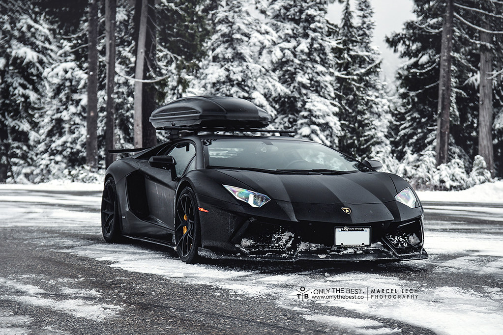 Une Lamborghini Aventador SVJ recouverte d'une housse de protection dans un garage chauffé.