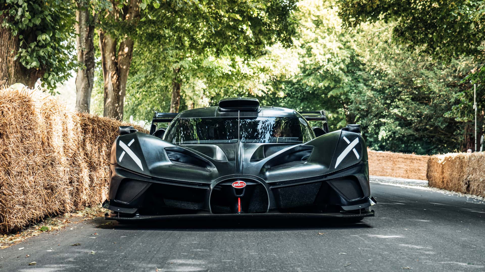 Une Koenigsegg et une Bugatti exposées au Festival de Goodwood 2023, entourées de spectateurs.