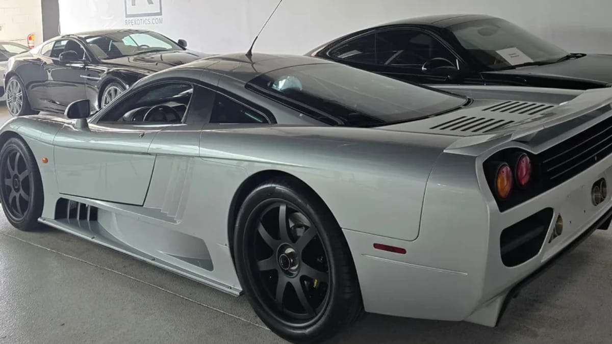 Une Saleen S7 noire, garée dans un garage de collection, avec des reflets brillants sur sa carrosserie.
