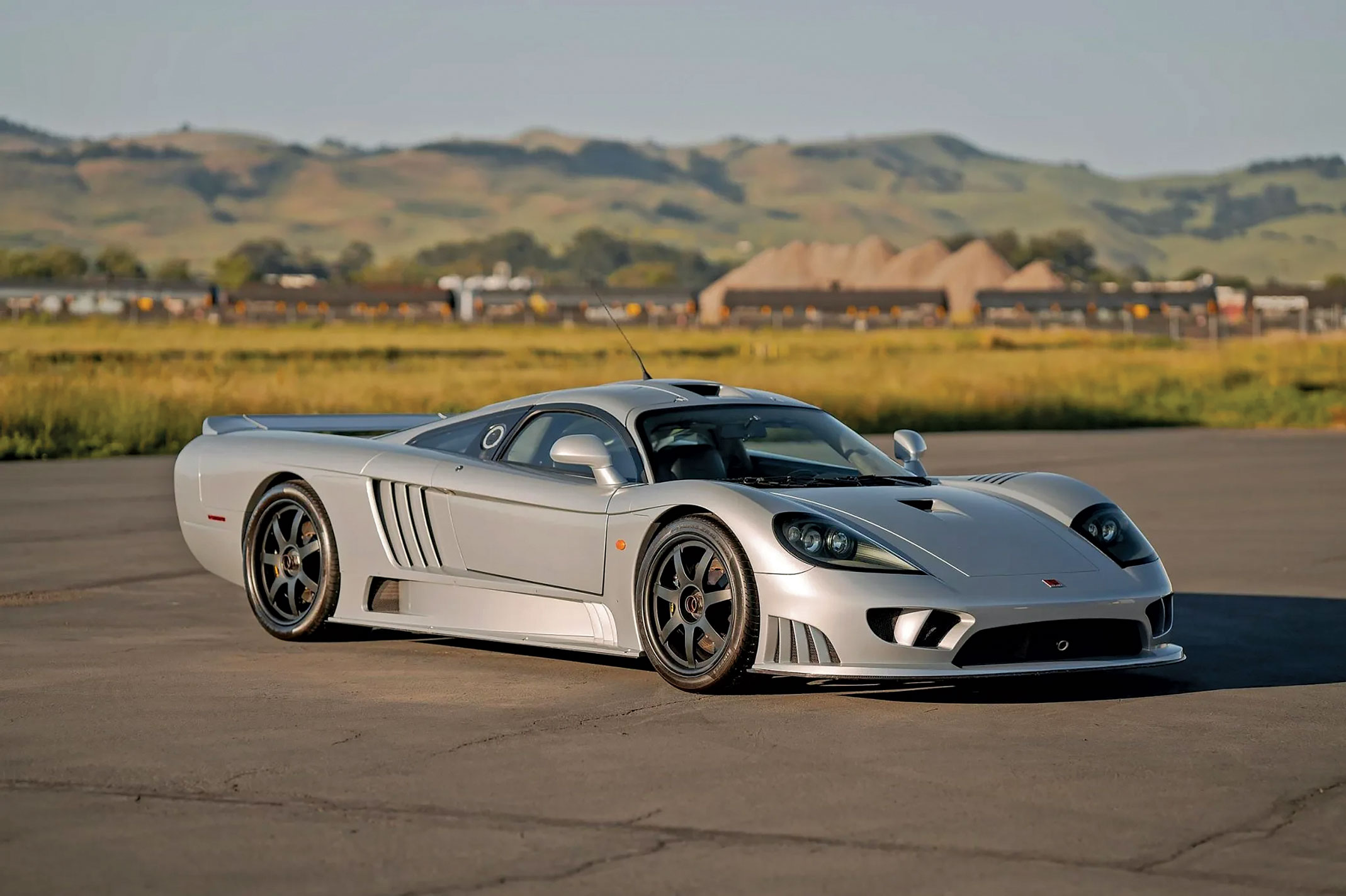 Vue latérale d'une Saleen S7 rouge, mettant en évidence ses lignes agressives et ses prises d'air proéminentes.