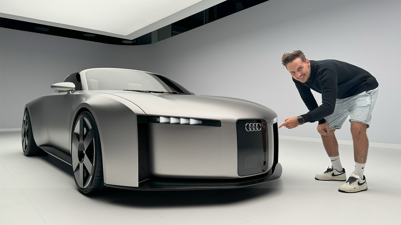 Un Audi Concept C 2027 argenté, aux lignes futuristes, exposé dans un environnement high-tech épuré.