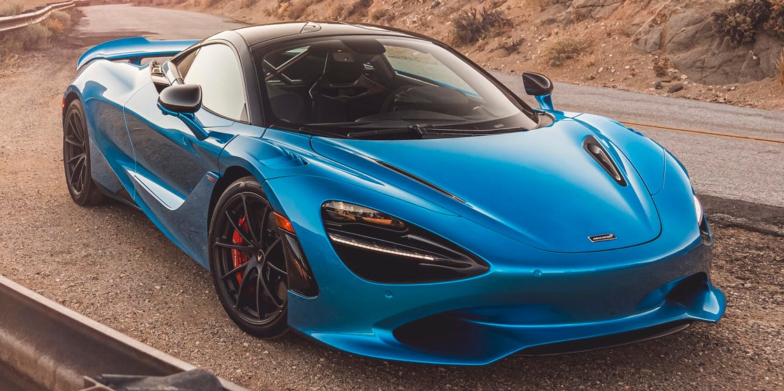 Mécanicien travaillant sur le moteur d'une McLaren 750S dans un garage moderne.