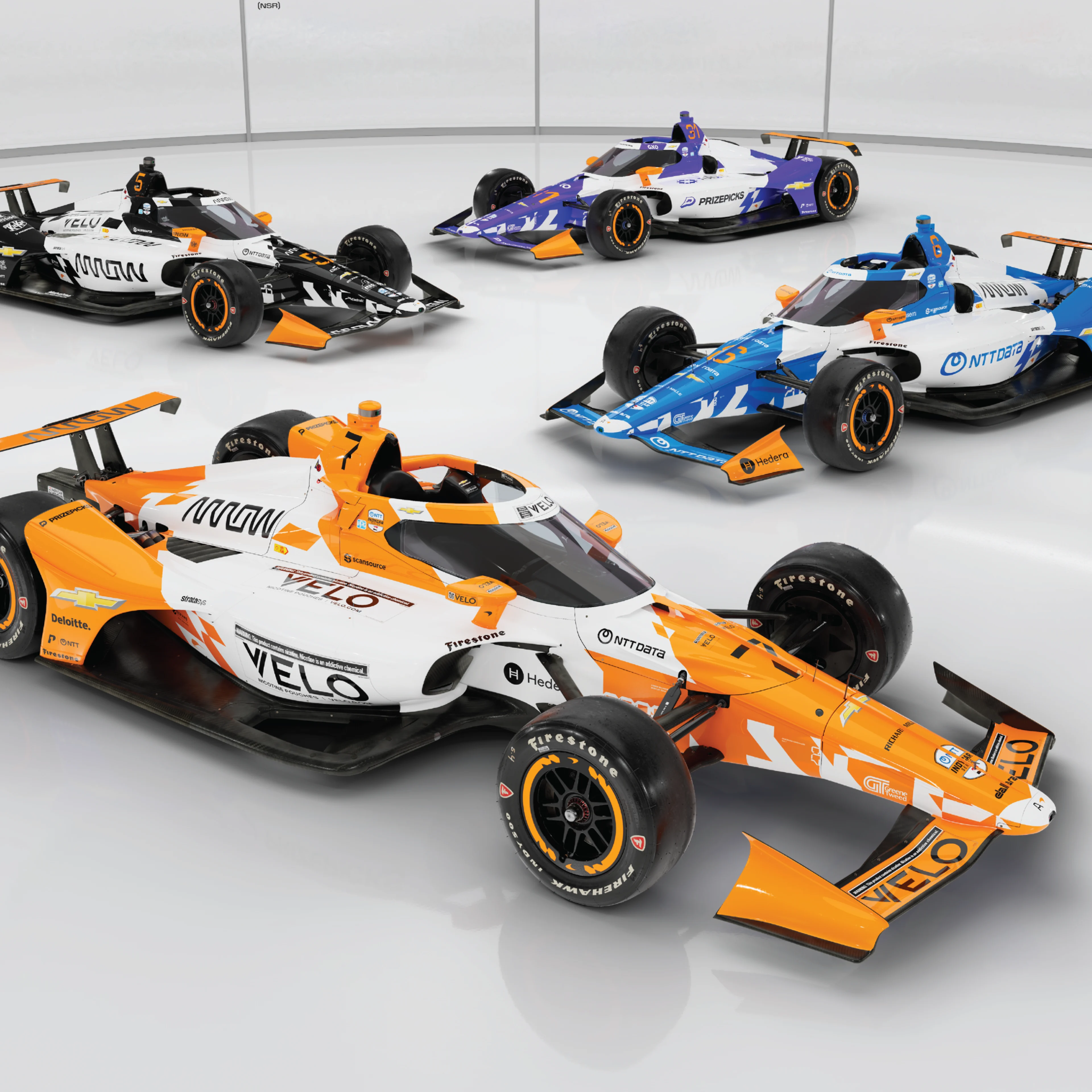 Quatre voitures de course Arrow McLaren Indy 500 2026 avec leurs nouvelles livrées colorées alignées sur la piste.