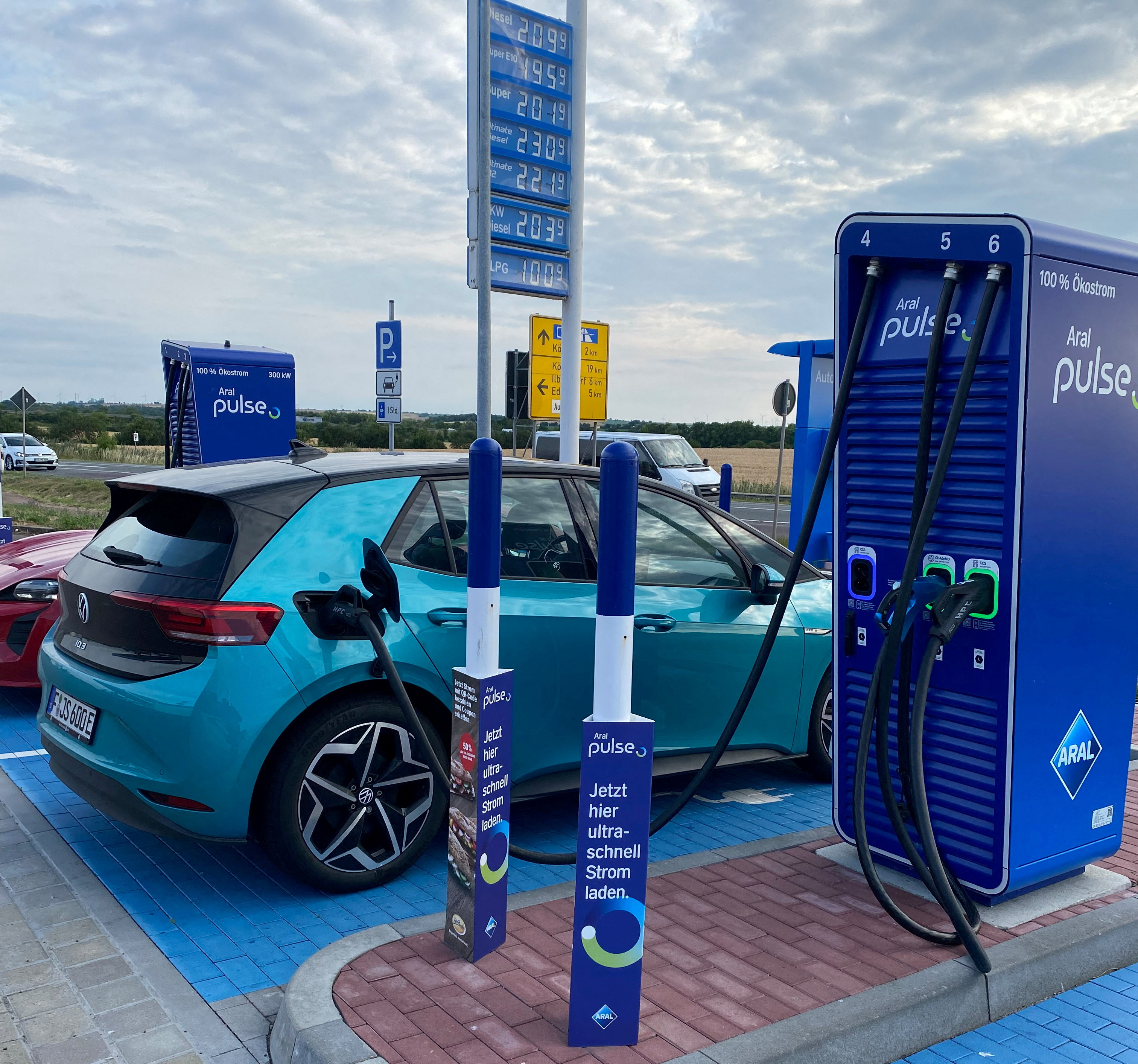 Image d'une station de recharge pour véhicules électriques en Allemagne avec une voiture en charge.