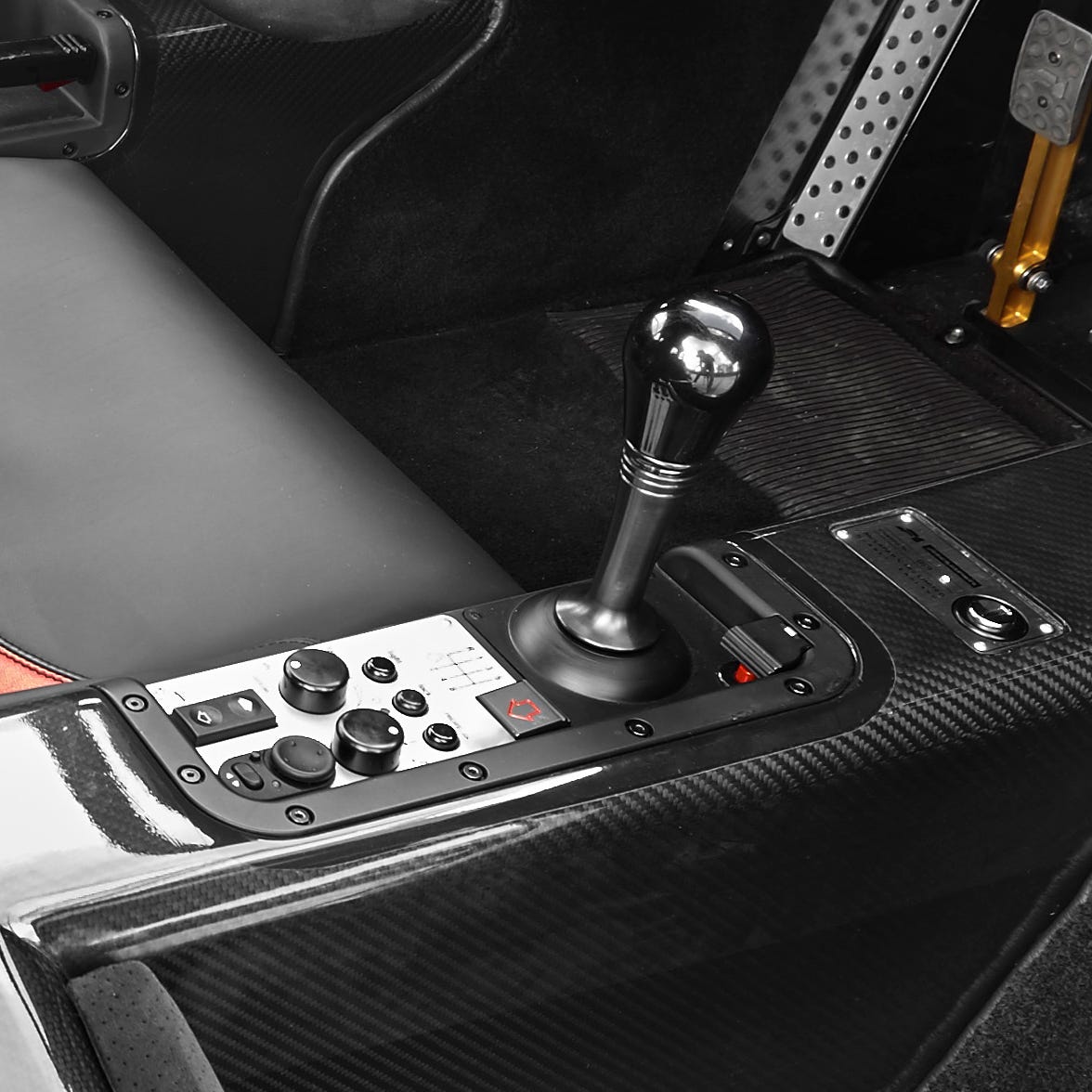 Vue intérieure d'une McLaren F1 classique avec un levier de vitesses manuel, montrant le poste de pilotage central.