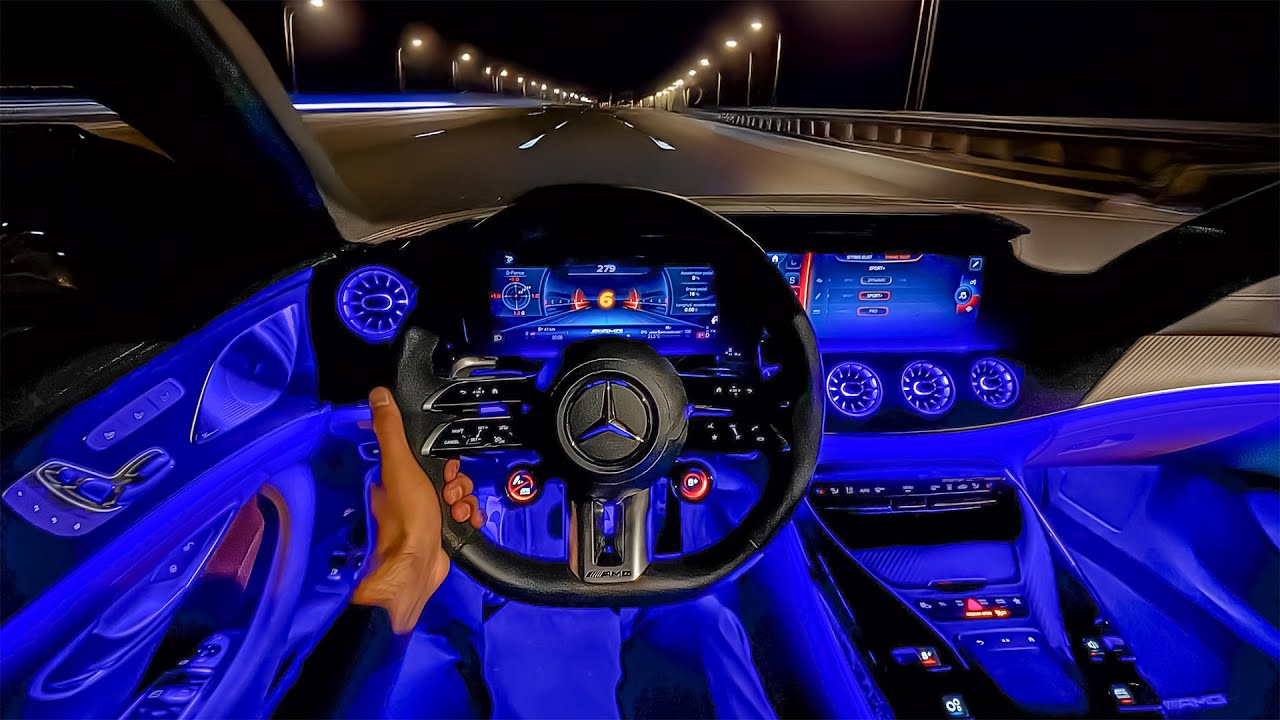 L'intérieur d'une Mercedes-AMG GT 63 avec des sièges en cuir noir, un volant sport et un grand écran central.