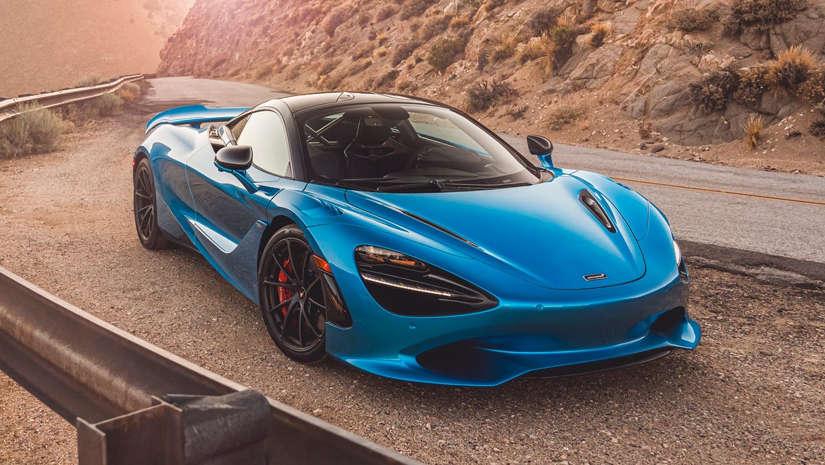 Une McLaren 750S rouge vif, garée sur une piste de course, symbolisant l'engagement de la marque envers les voitures de sport.