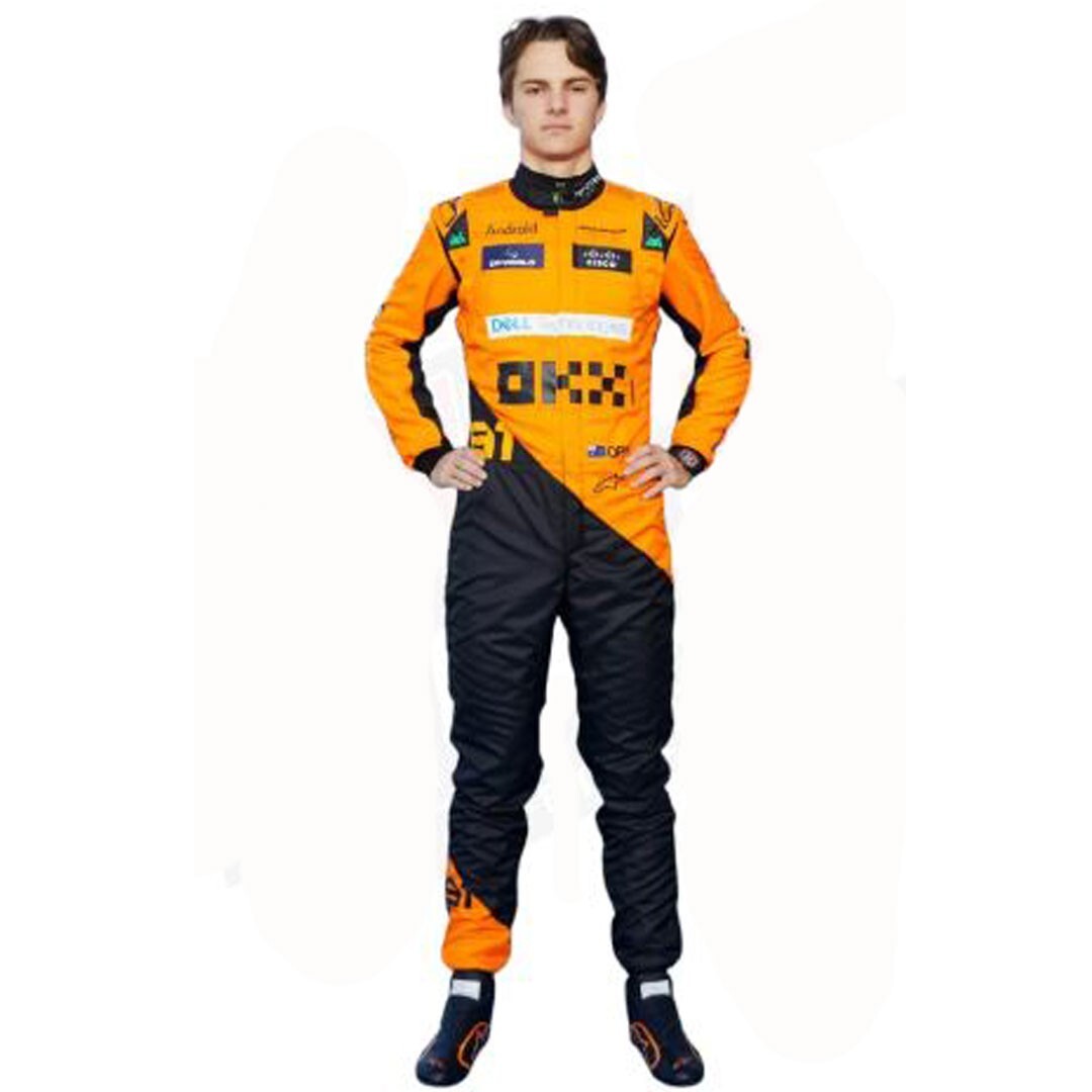 Oscar Piastri, pilote de Formule 1, en combinaison de course McLaren, posant à côté de sa voiture sur une piste.